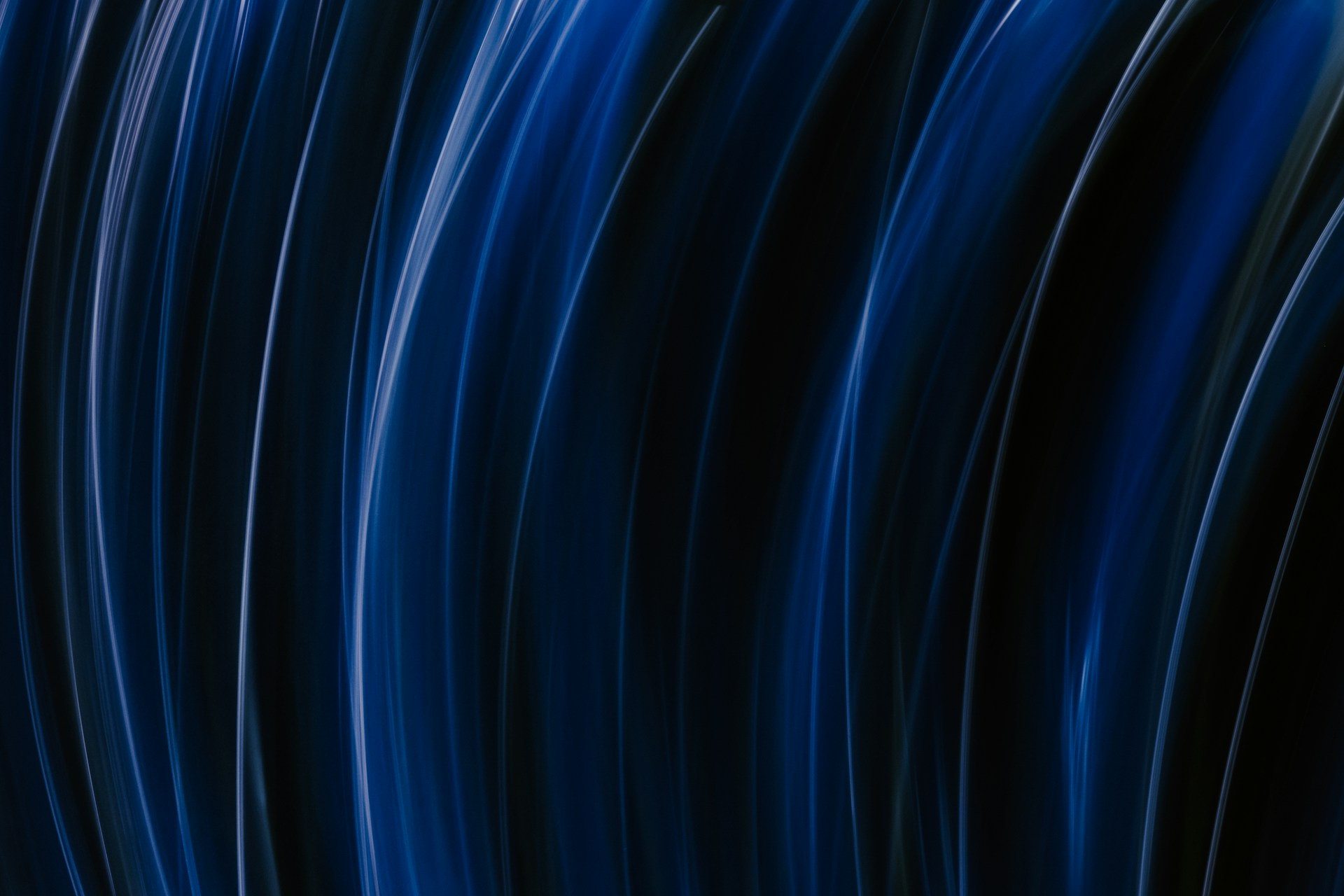 an abstract photo of a curved building with a blue sky in the background