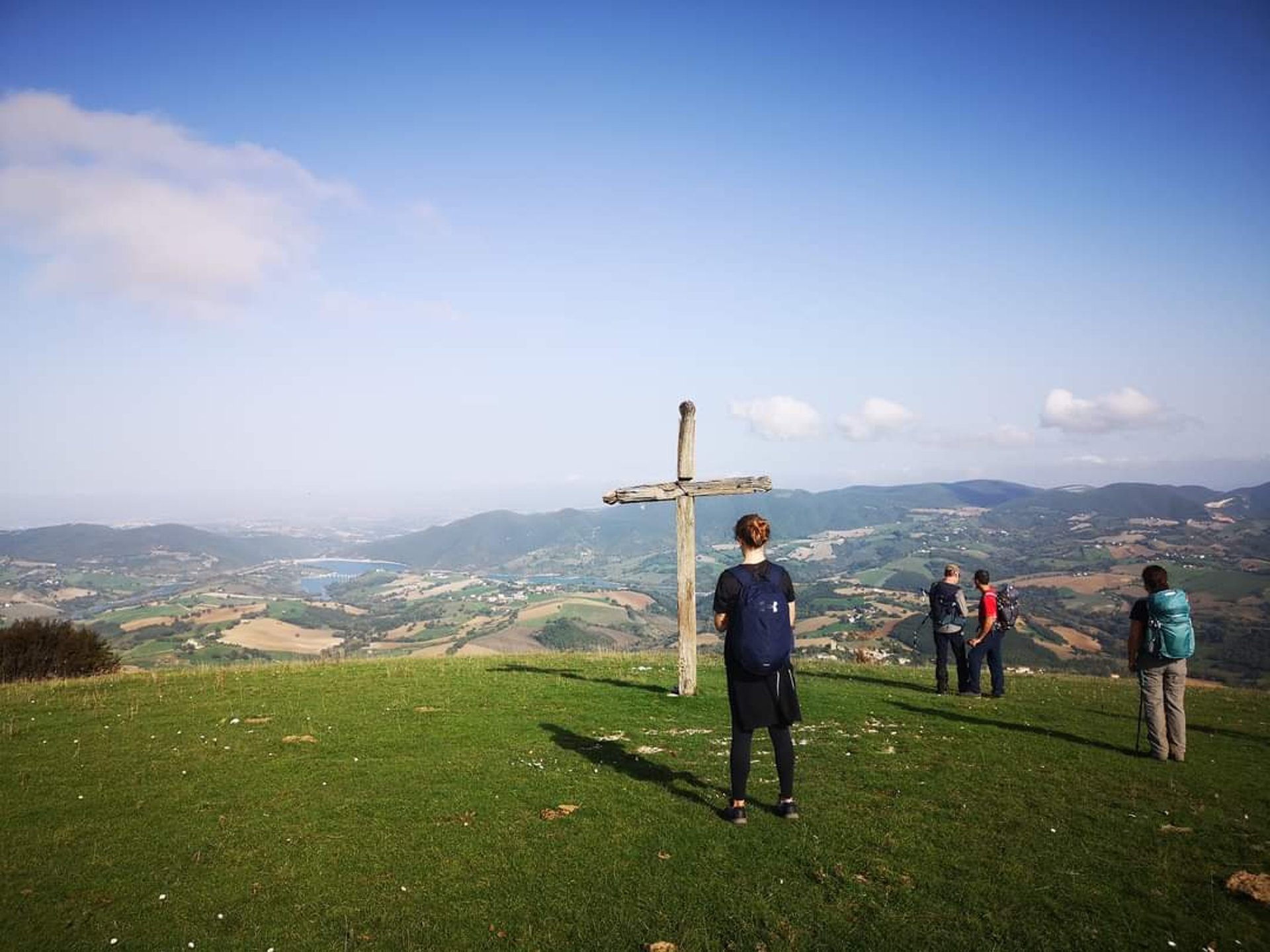 brown concrete building near green trees under blue sky during daytime