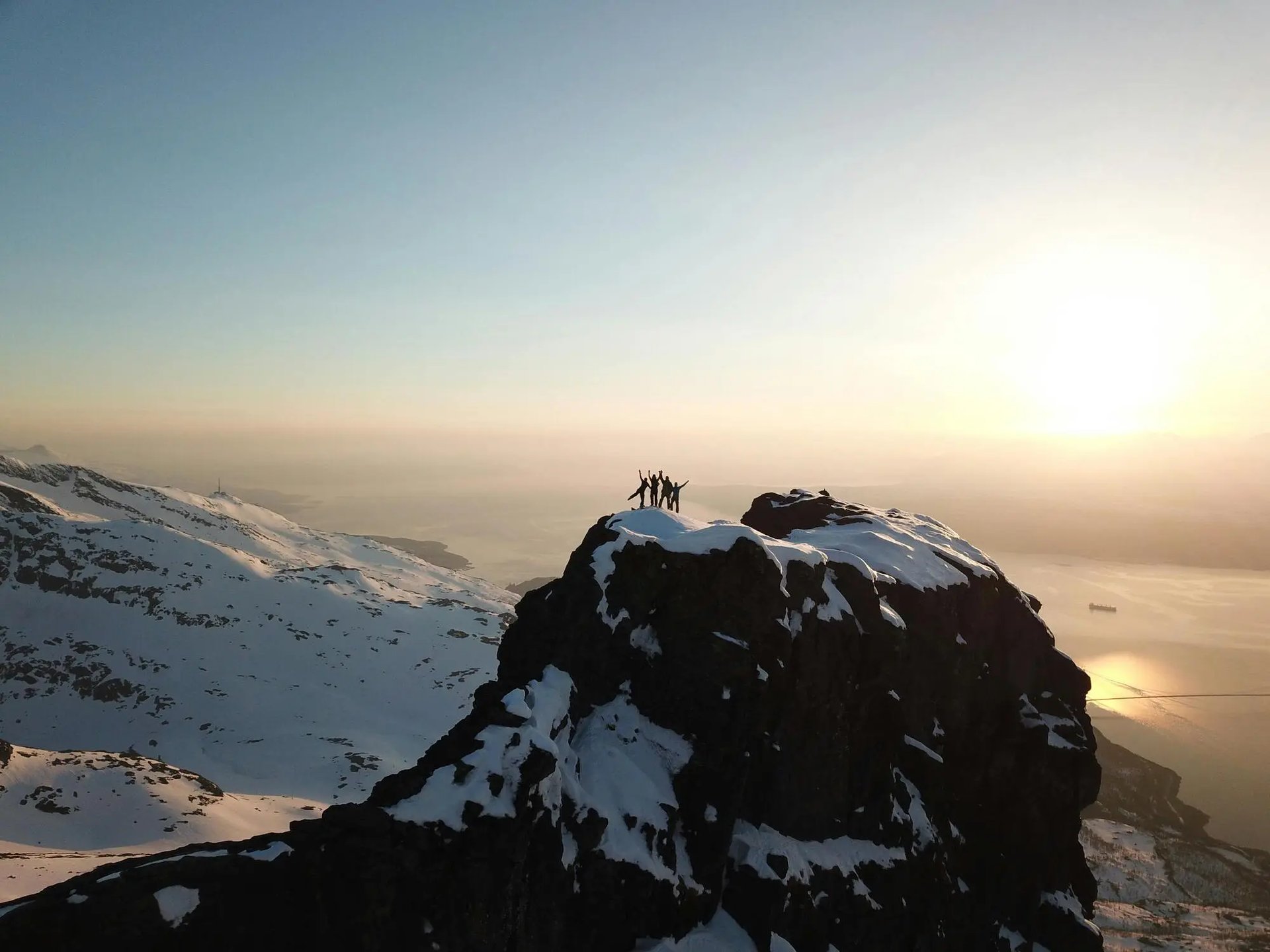 man standing on rock looking towards lake