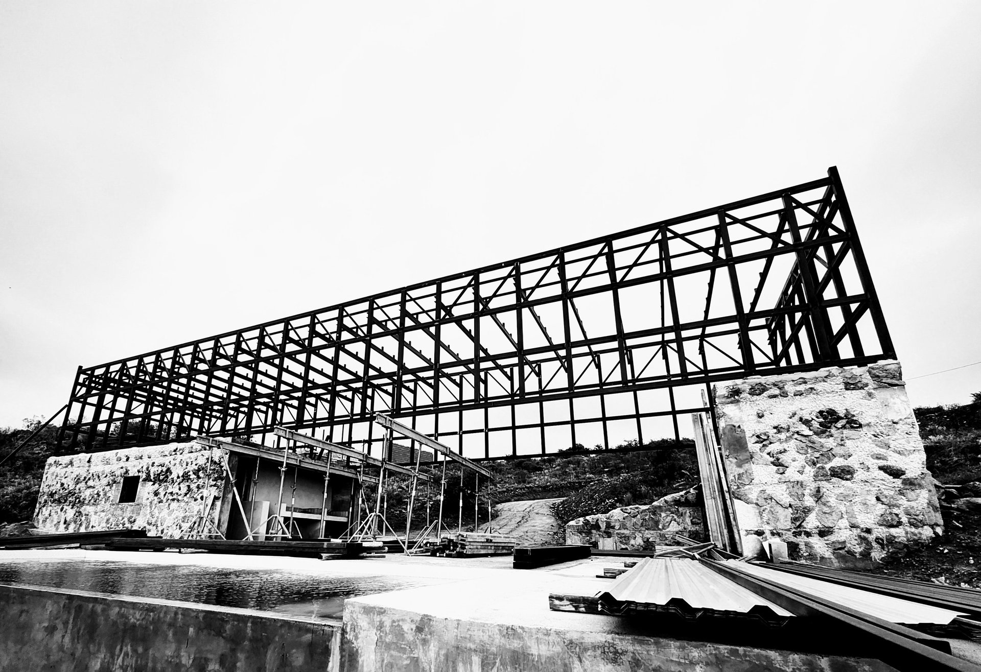 una construcción metálica apoyada en bloques de hormigón y piedra. una casa como un puente en el paisaje.arquitectura sentido