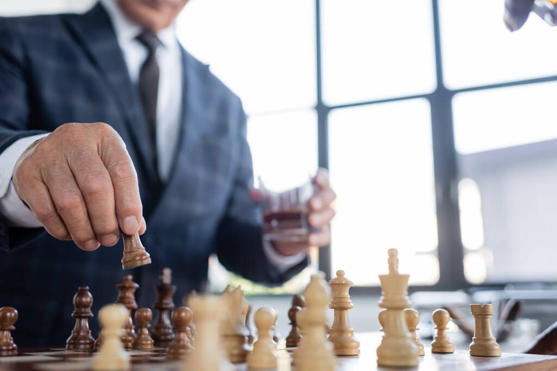 depth of field photography of man playing chess