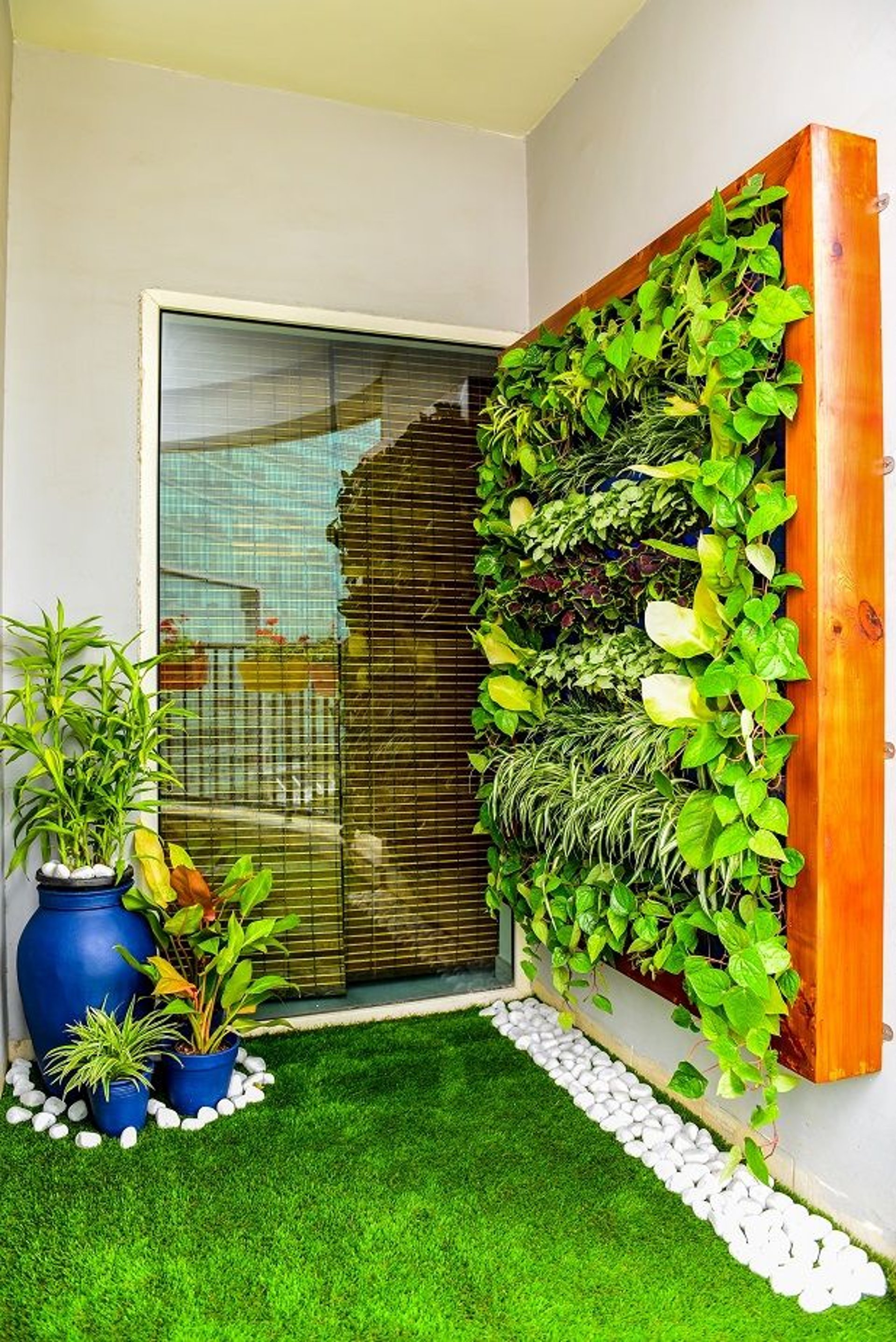 A lush, vibrant, low-maintenance vertical garden by FM Landscaping for apartment balcony