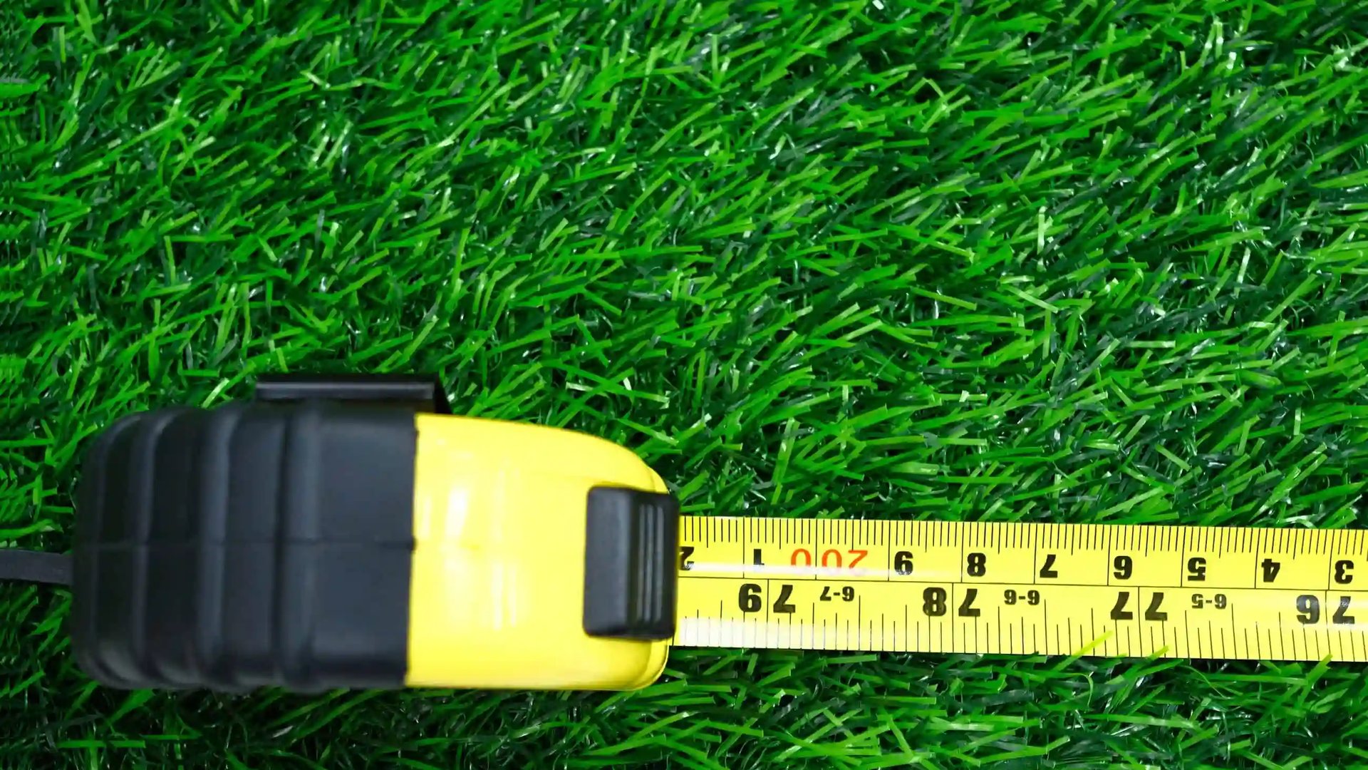 A measuring tape on a lush green lawn for cost calculation