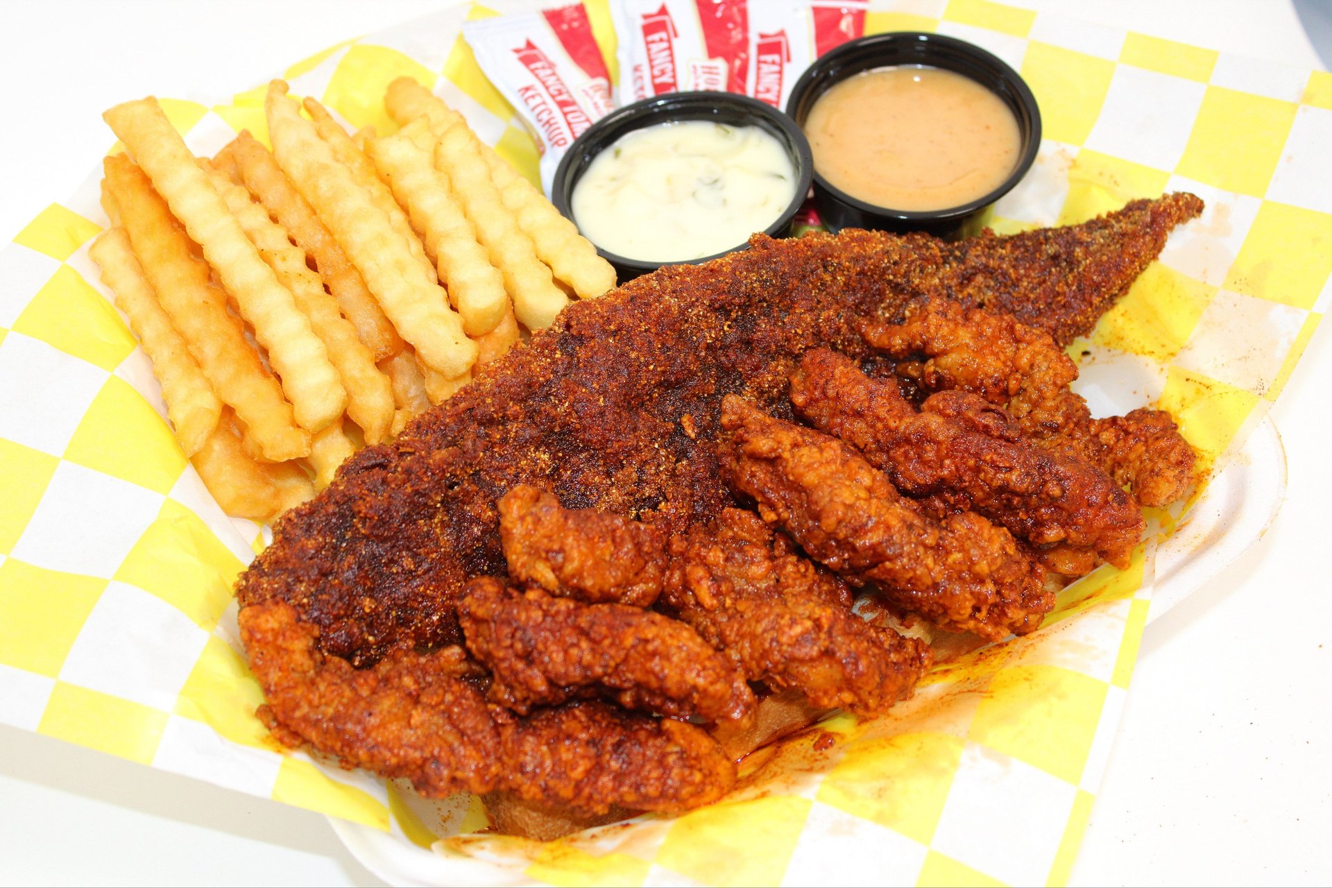 fried chicken on red and white checkered paper plate