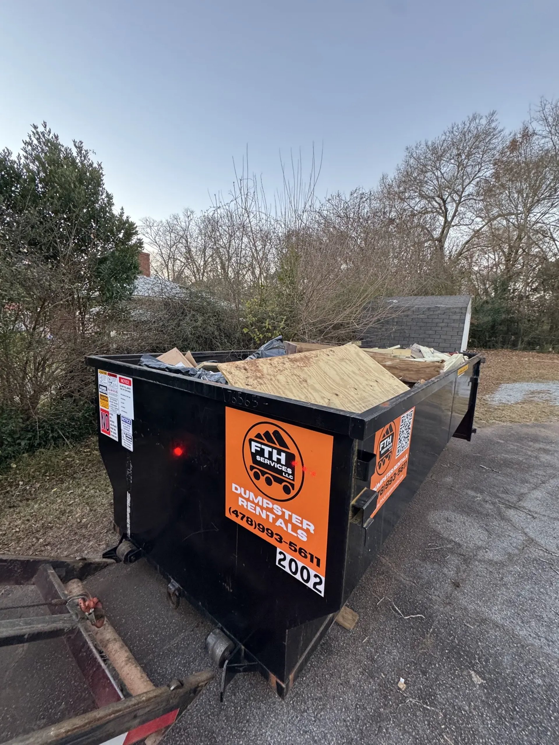 This picture shows a 20 yard dumpster provided by FTH Services delivered in Jackson Ga and set up on an asphalt driveway.  