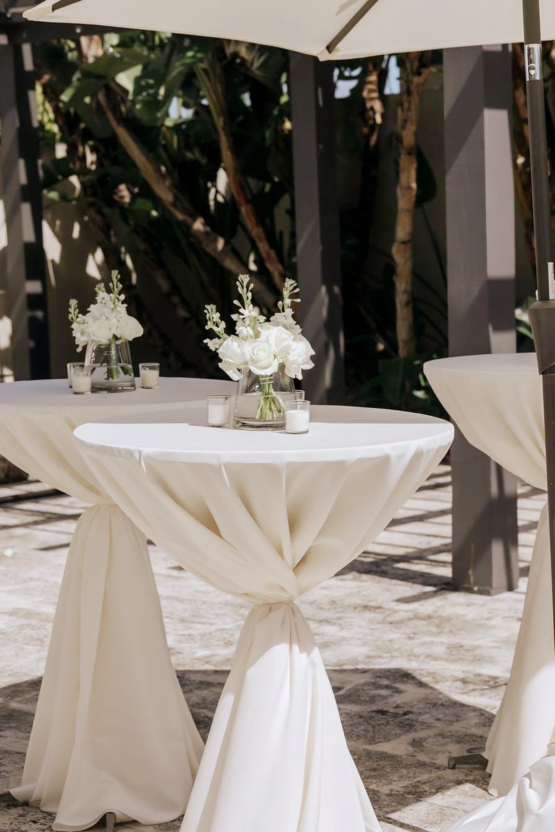 Mesas de coctel para eventos decoradas con manteleria blanca y flores