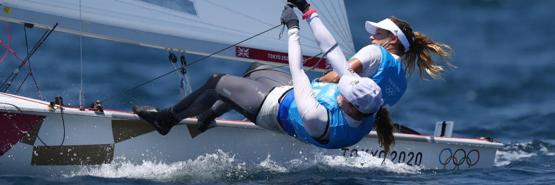 En kvinna seglar en mindre segelbåt.