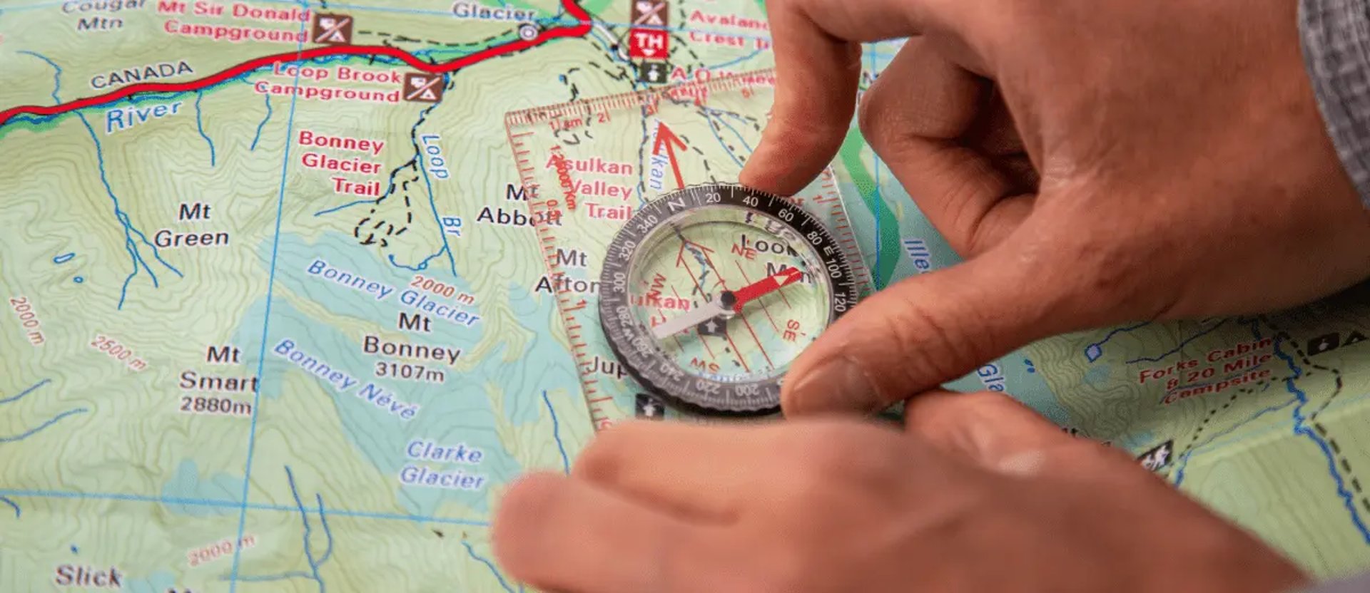 En hand håller en kompas spå en karta för att hitta i mål.