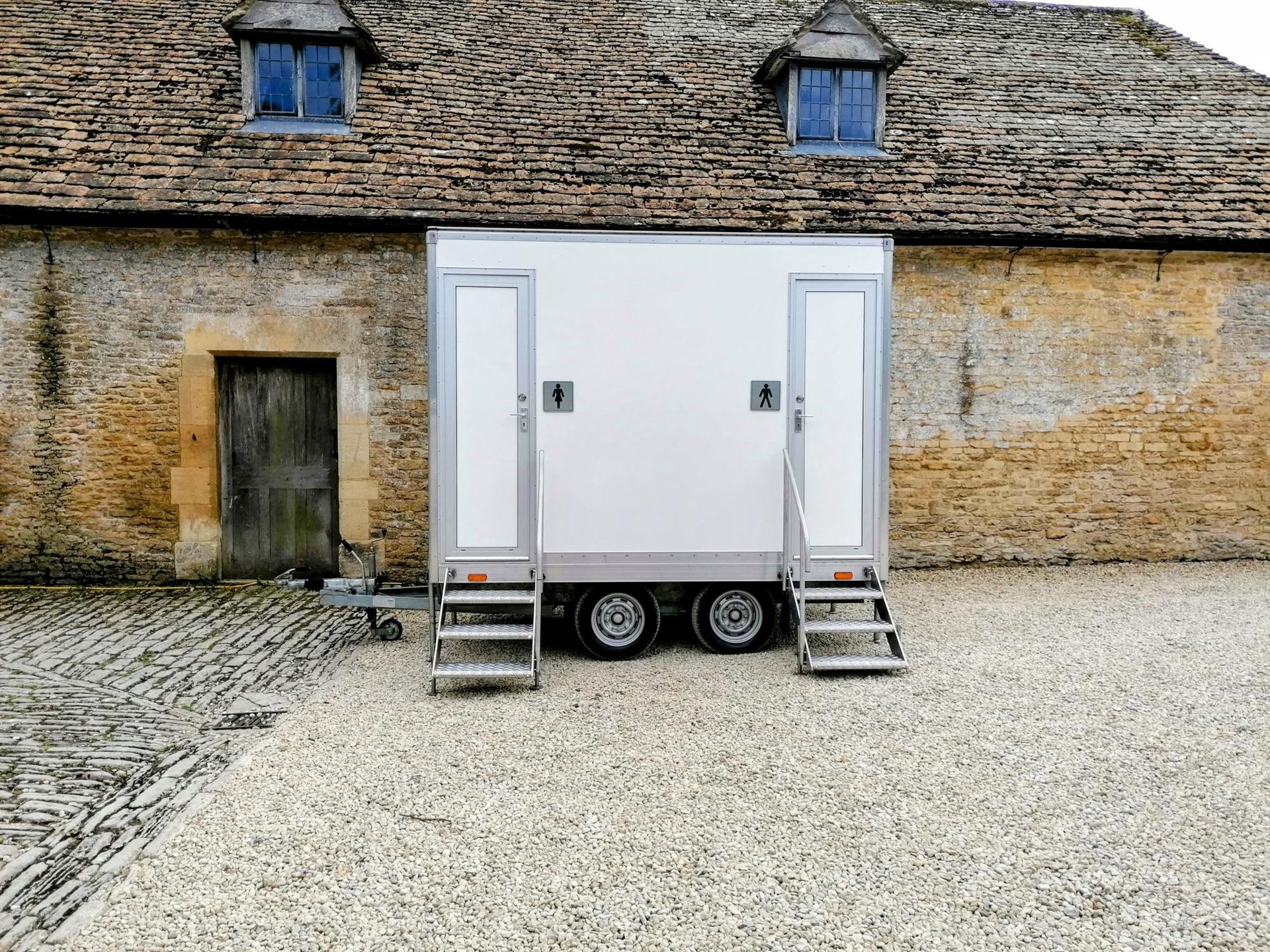 4 bay luxury toilet trailer set up in a field for a wedding