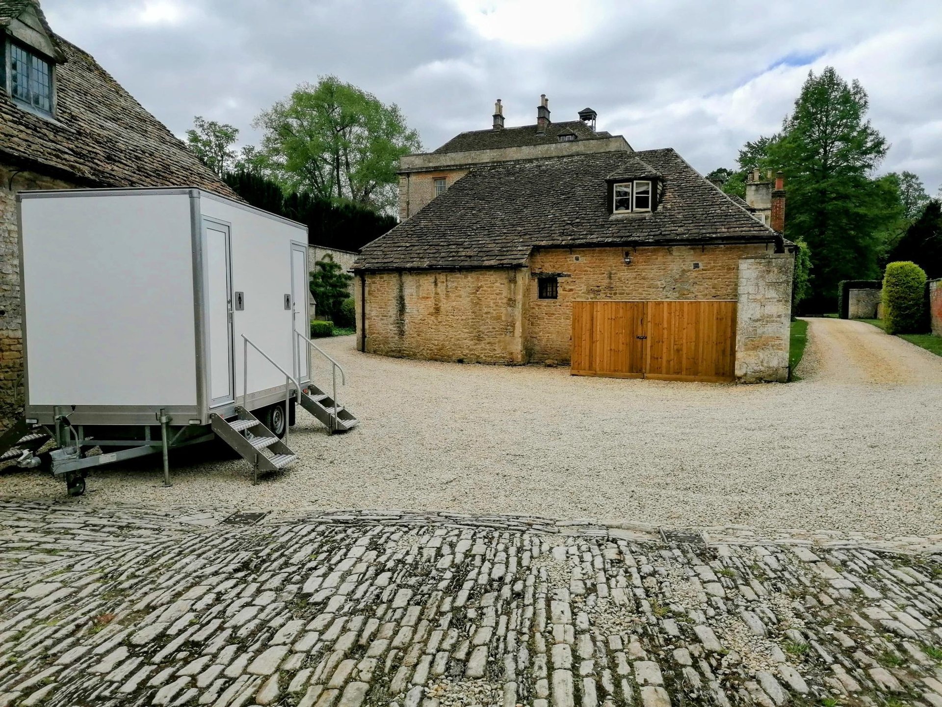 4 bay luxury toilet trailer set up in a field for a wedding