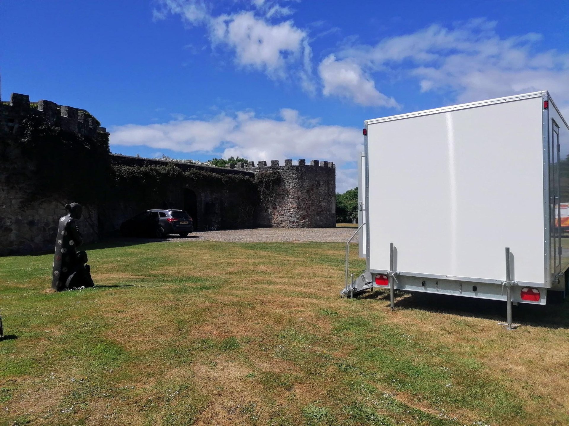 4 bay luxury toilet trailer set up in a field for a wedding