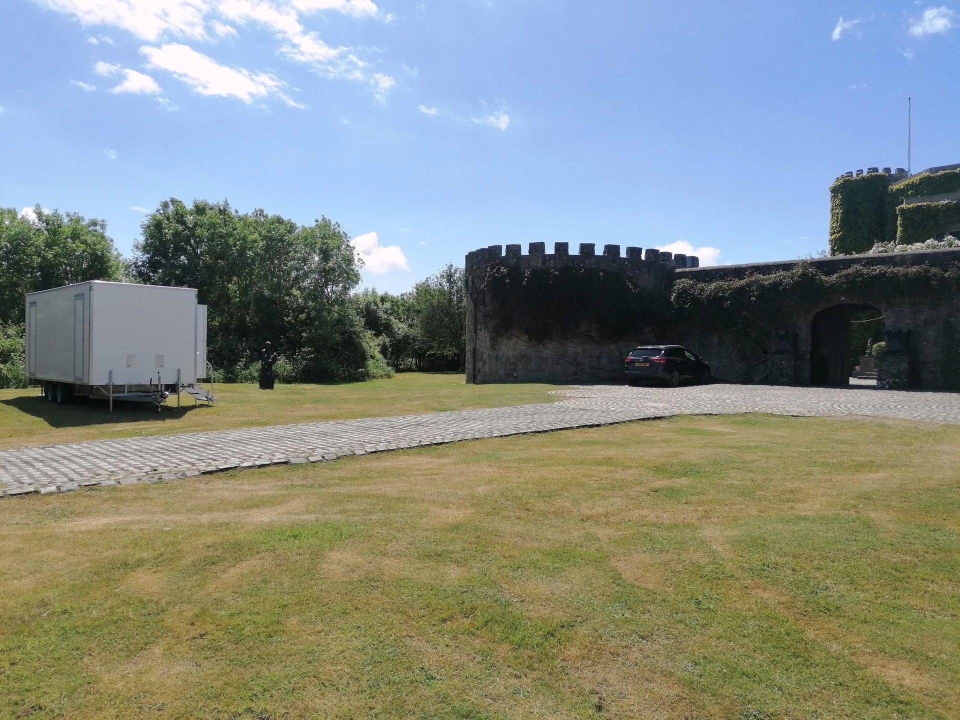 4 bay luxury toilet trailer set up in a field for a wedding