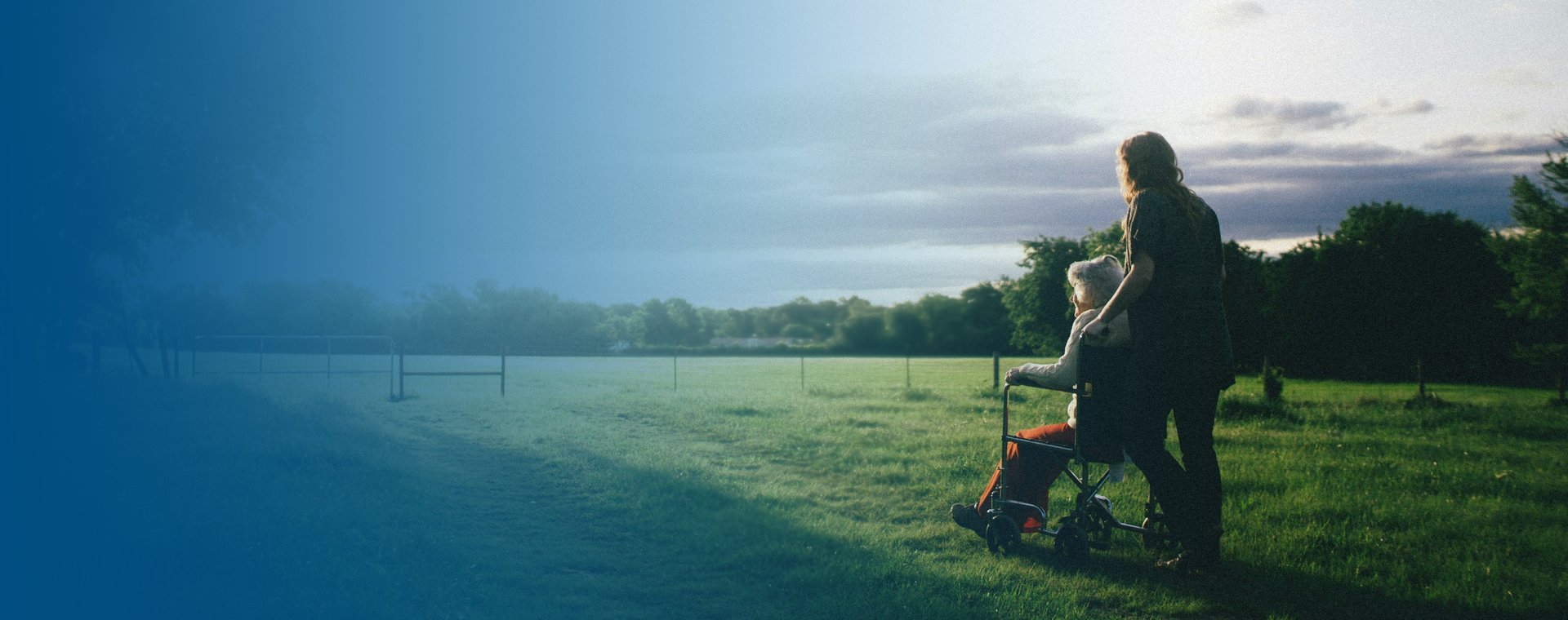 two person sitting on rock staring at body of water during daytime