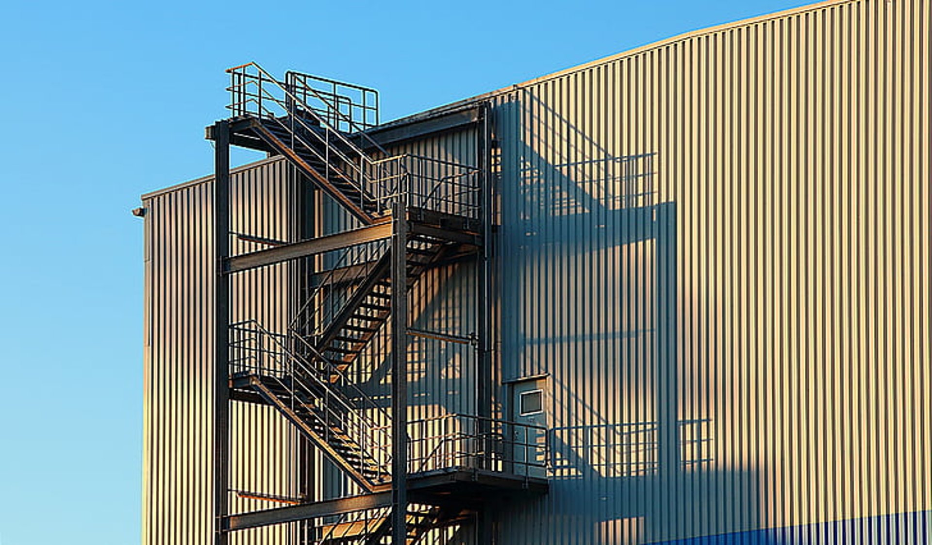 a tall blue building with a spiral staircase