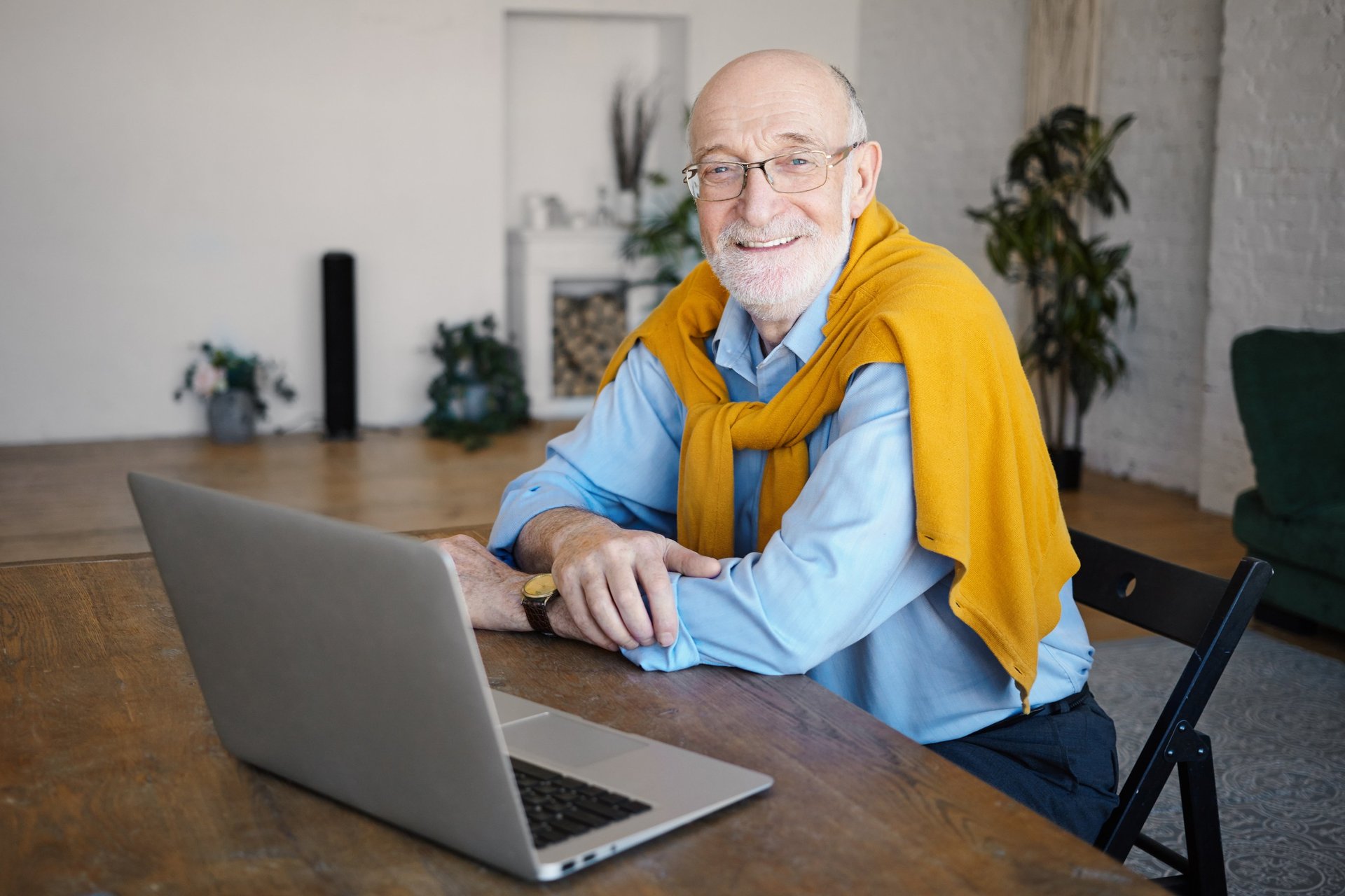 a man sitting at a table using a laptop computer