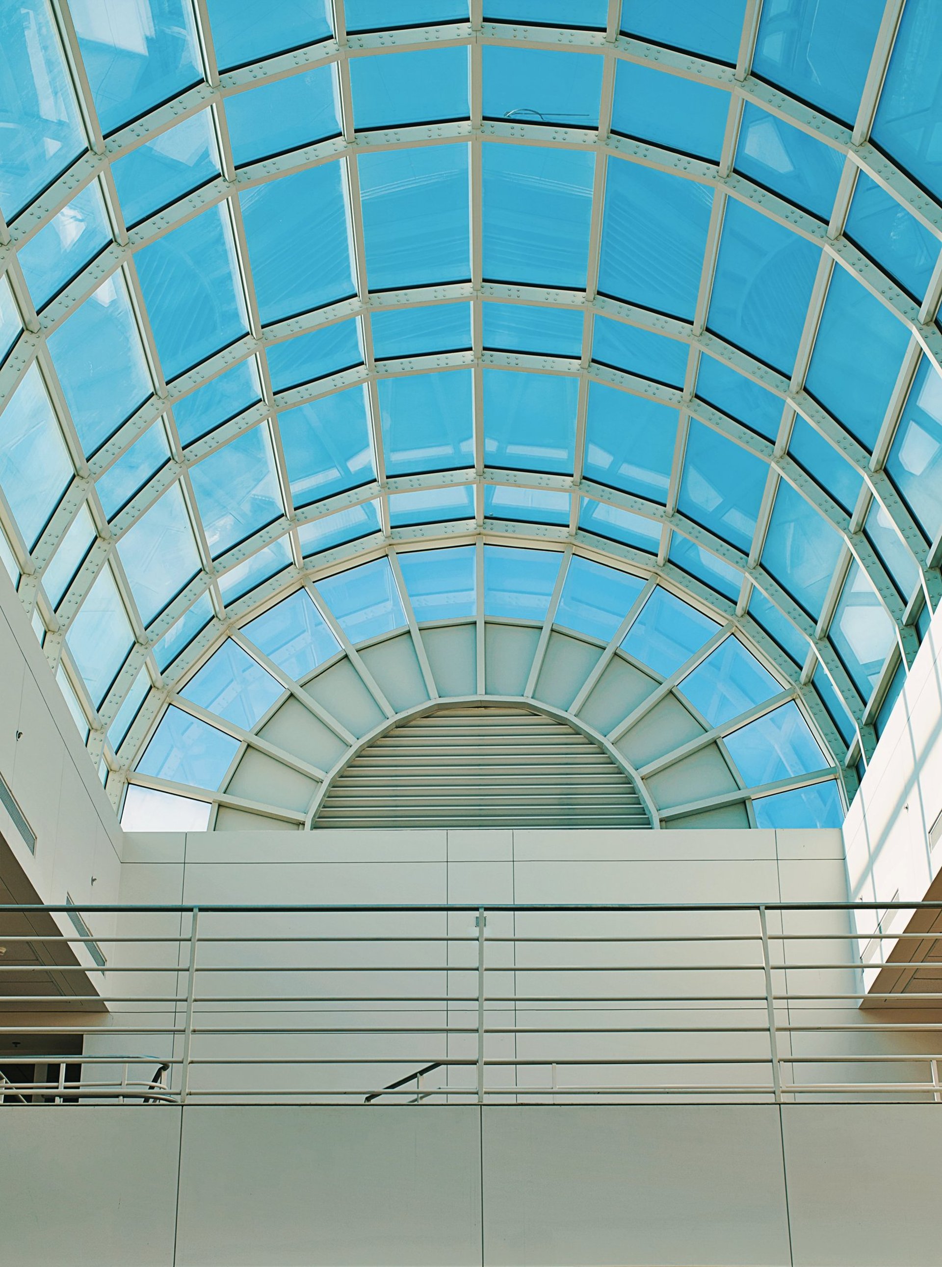 an abstract photo of a curved building with a blue sky in the background