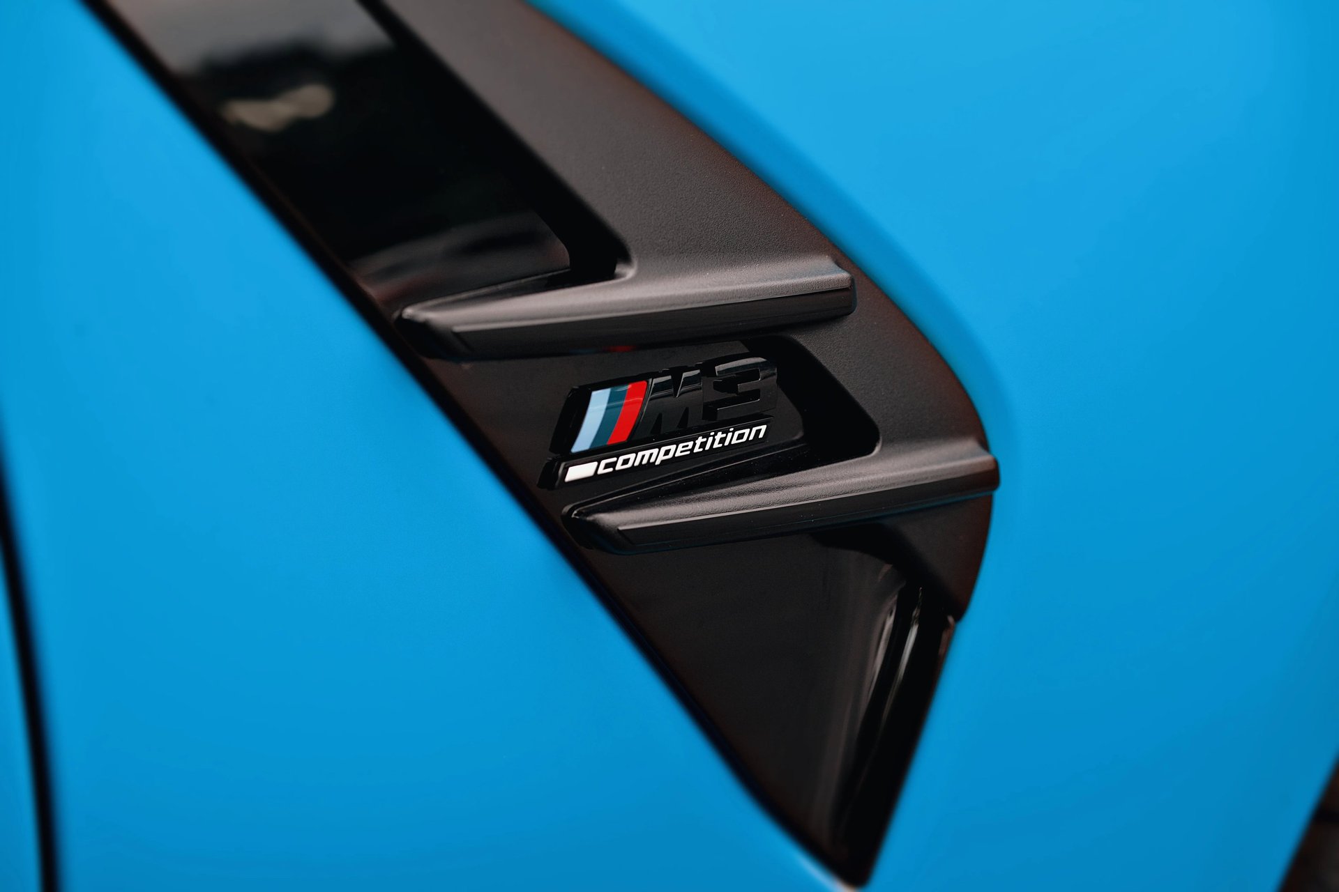 Electric blue BMW M3 Competition XDrive car photography at 704 Exotics in Charlotte, North Carolina.