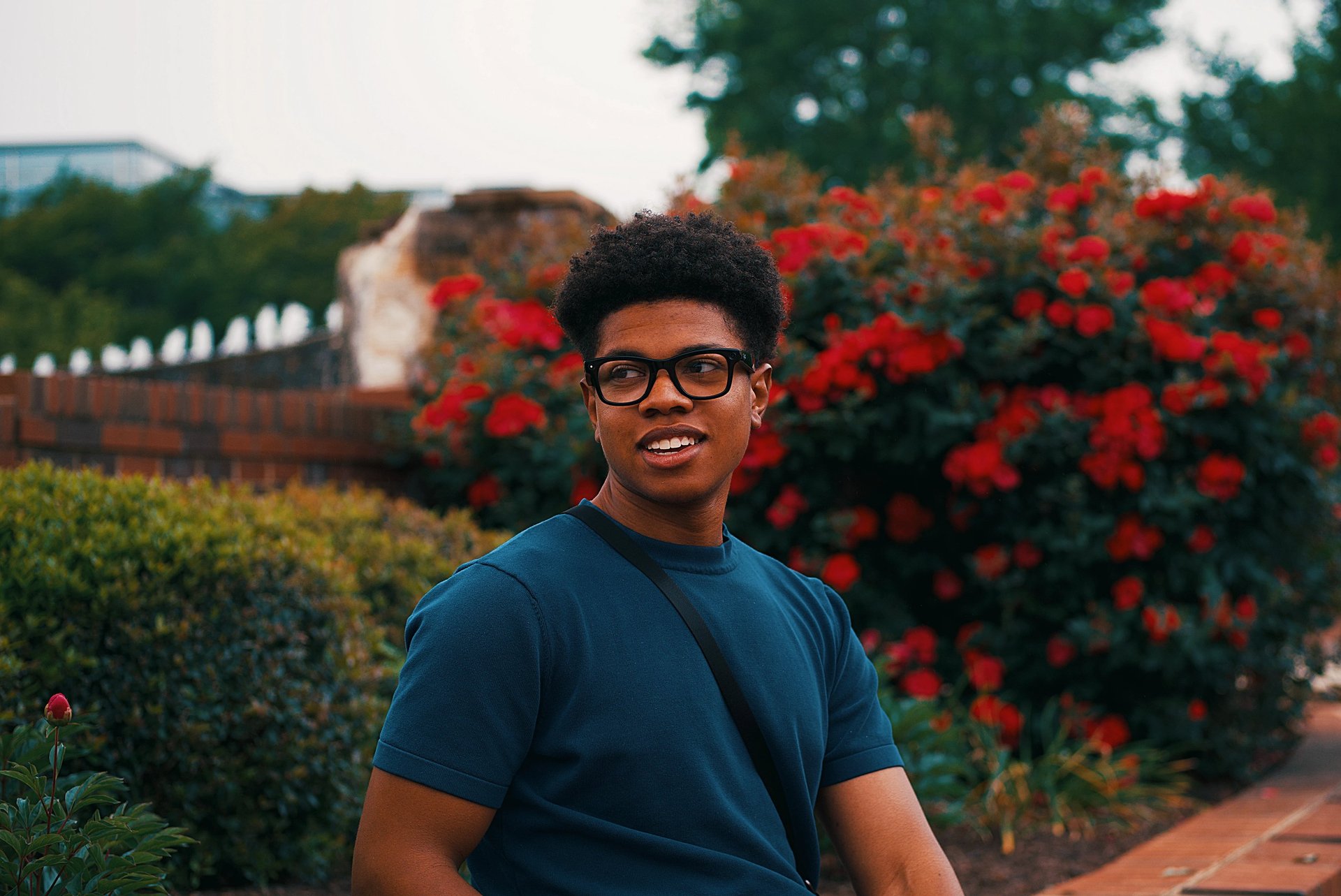 Young college black woman smiling underneath autumn trees while birdwatching.