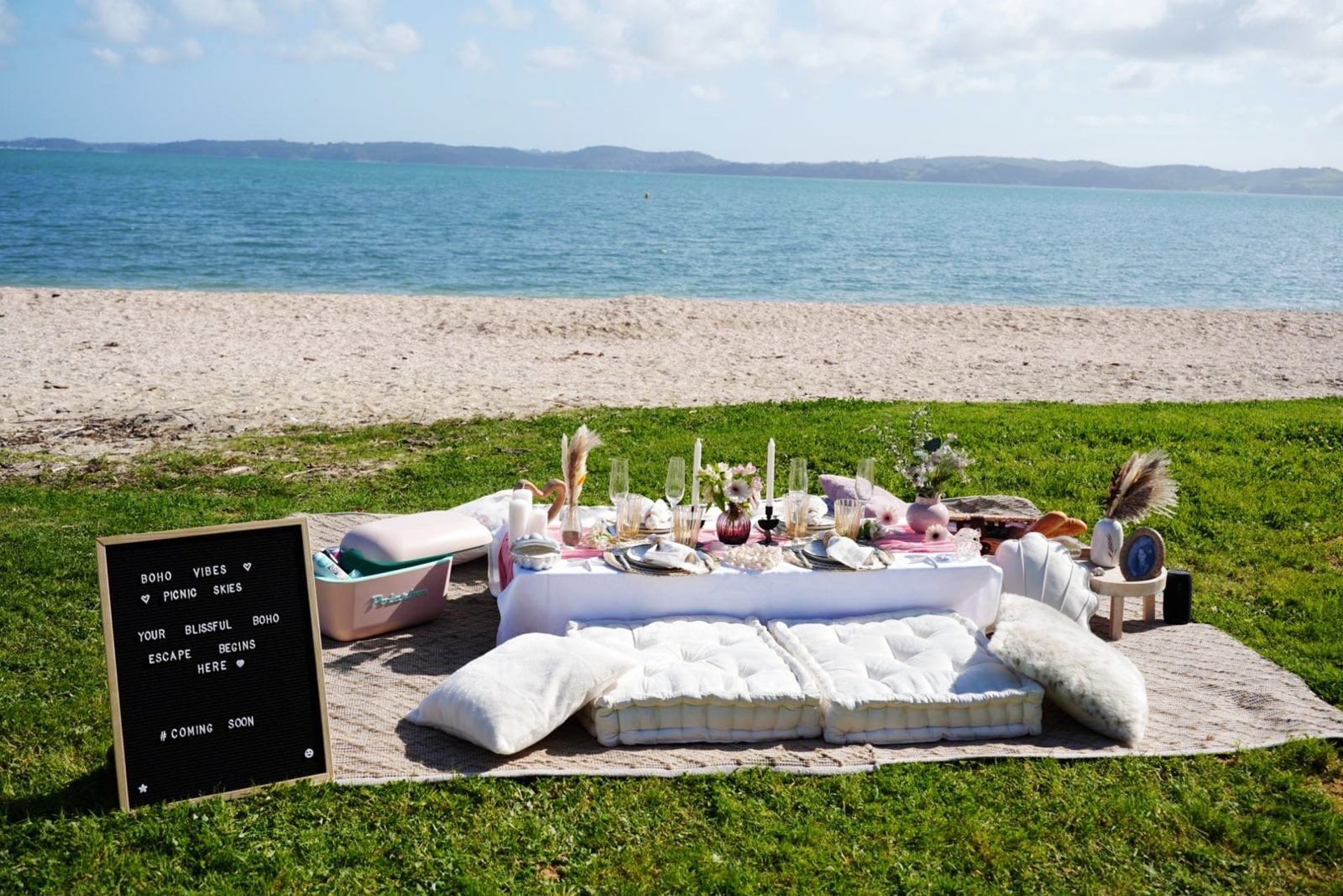 A table topped with a vase filled with flowers next to a bottle of wine