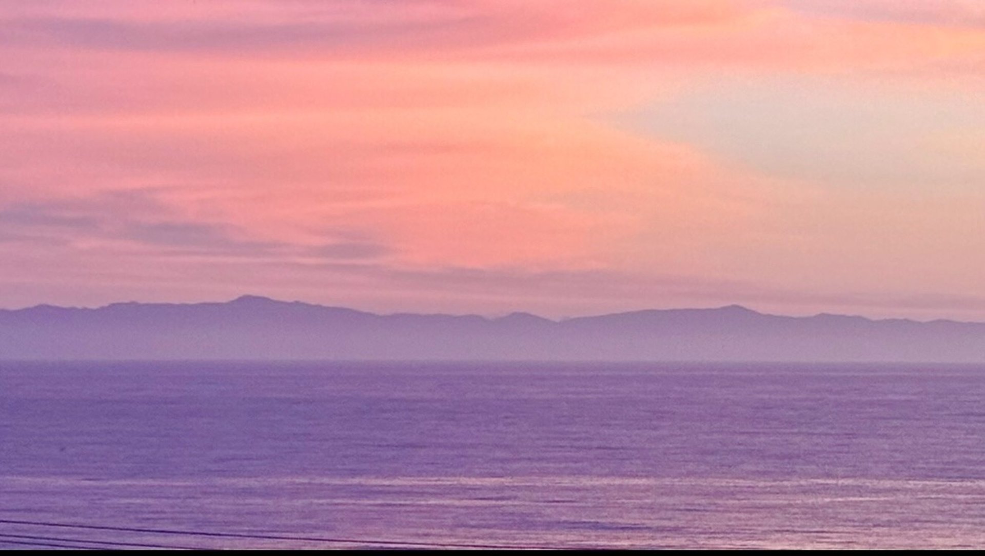 a sandy beach with rocks and a body of water
