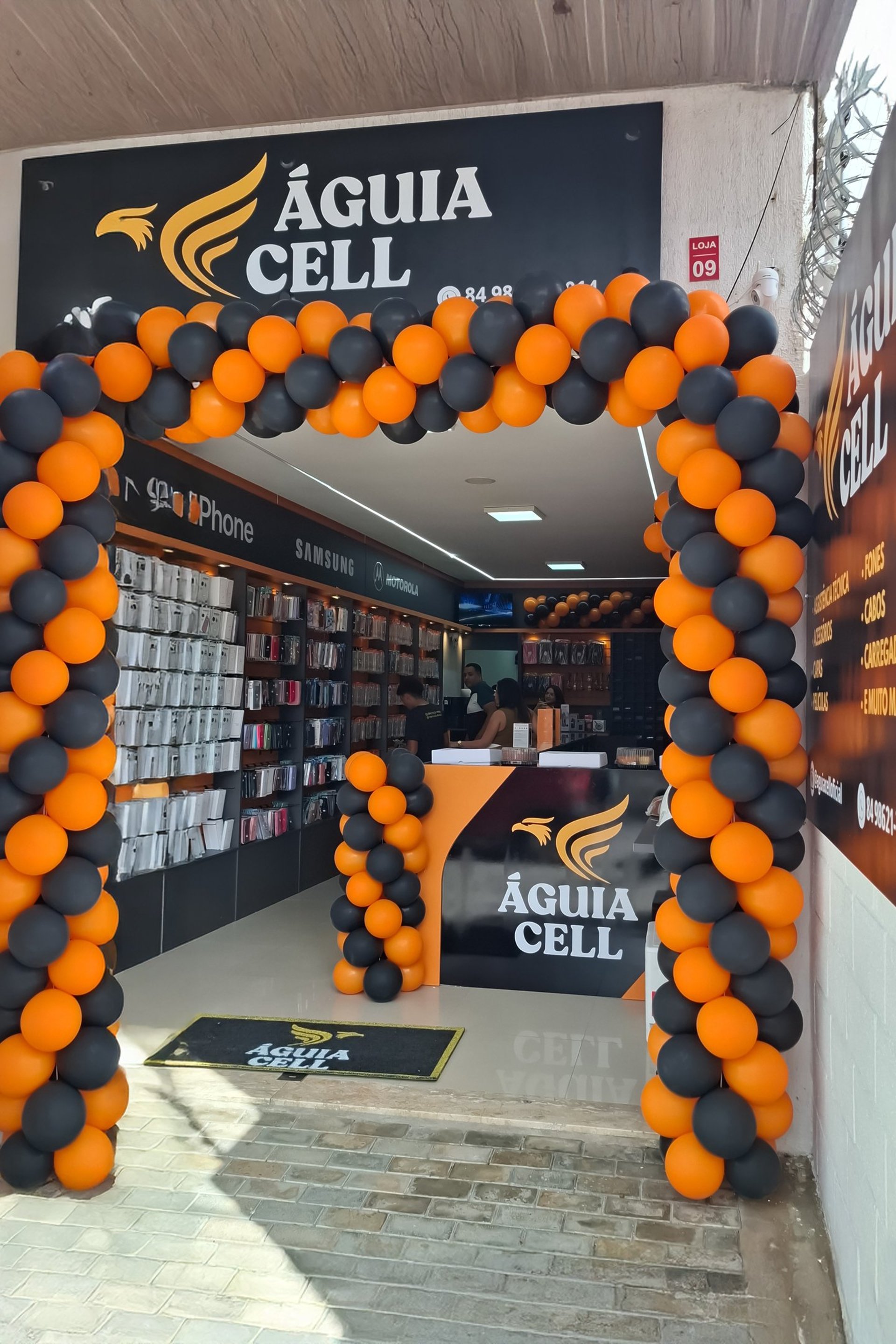 imagem mostra a fachada da loja Aguia Cell Parnamirim com os armarios e pratileiras de produtos e uma fachada decorada