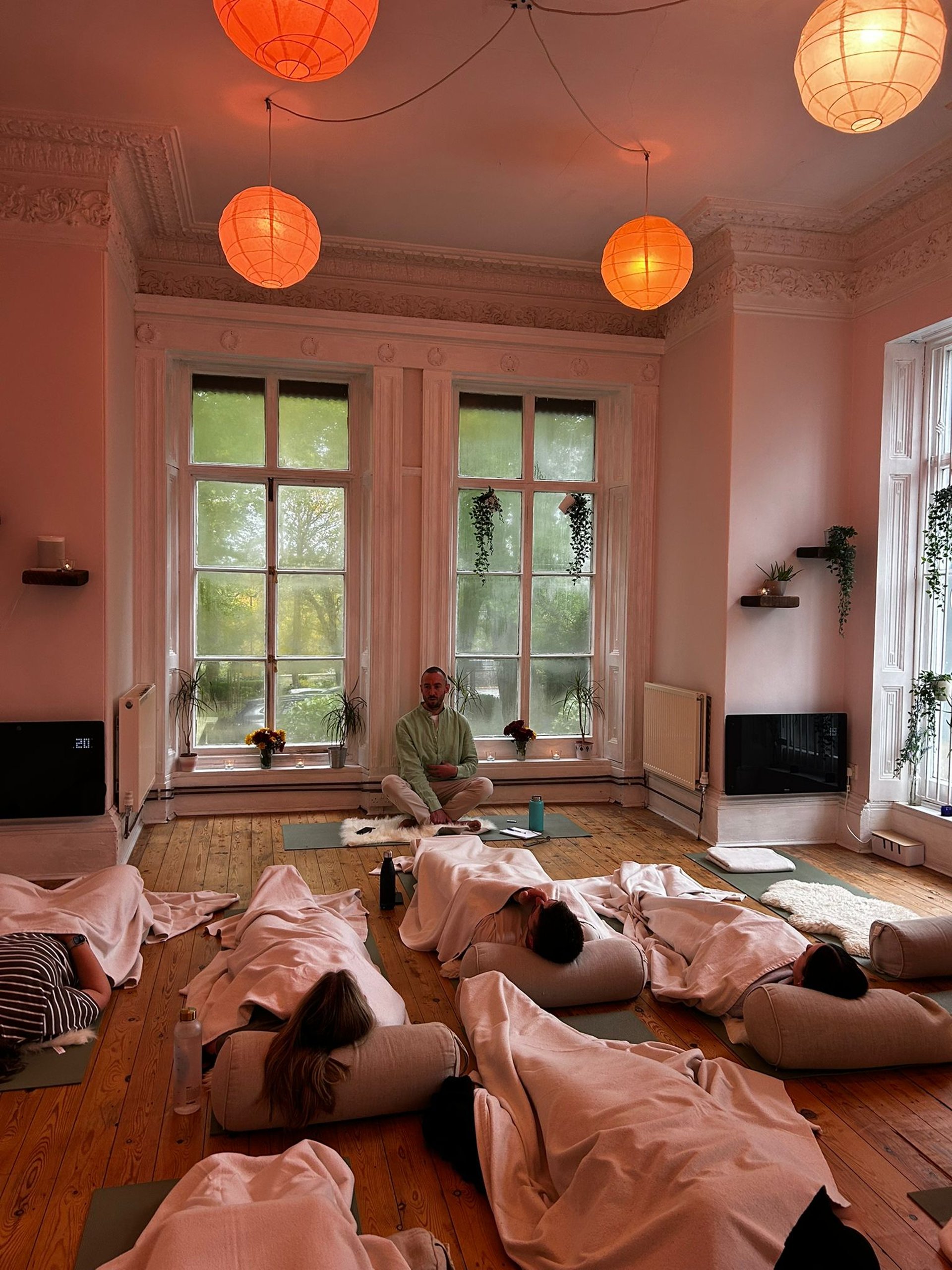 woman in black tank top and black pants bending her body on floor