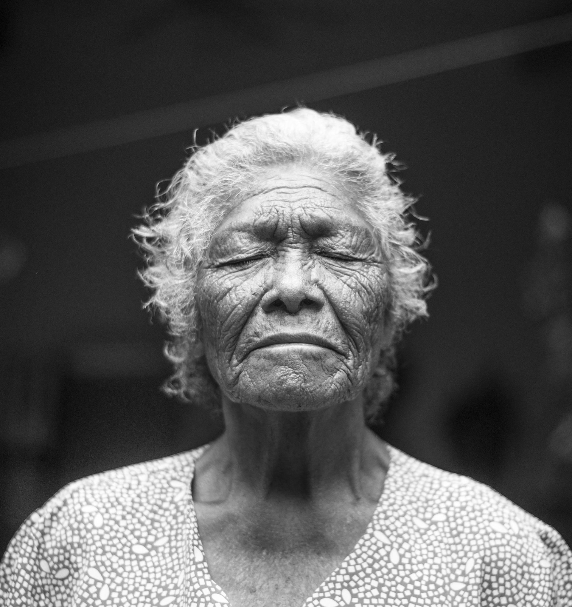 grayscale photo of closed-eyes woman