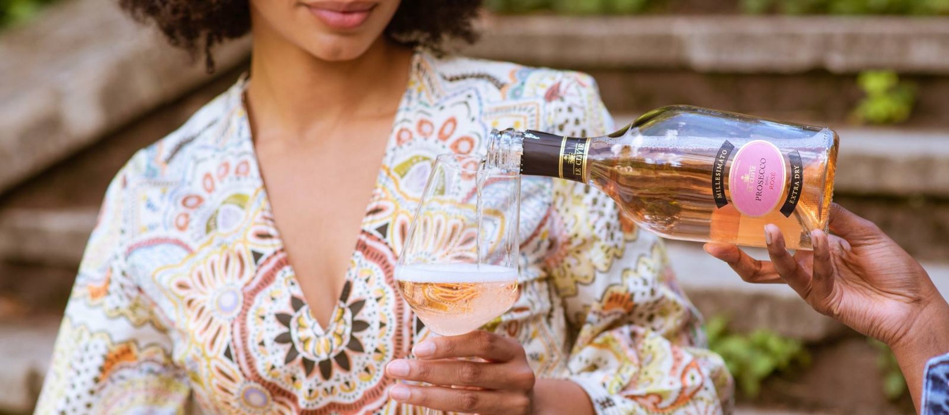person pouring red wine on wine glass