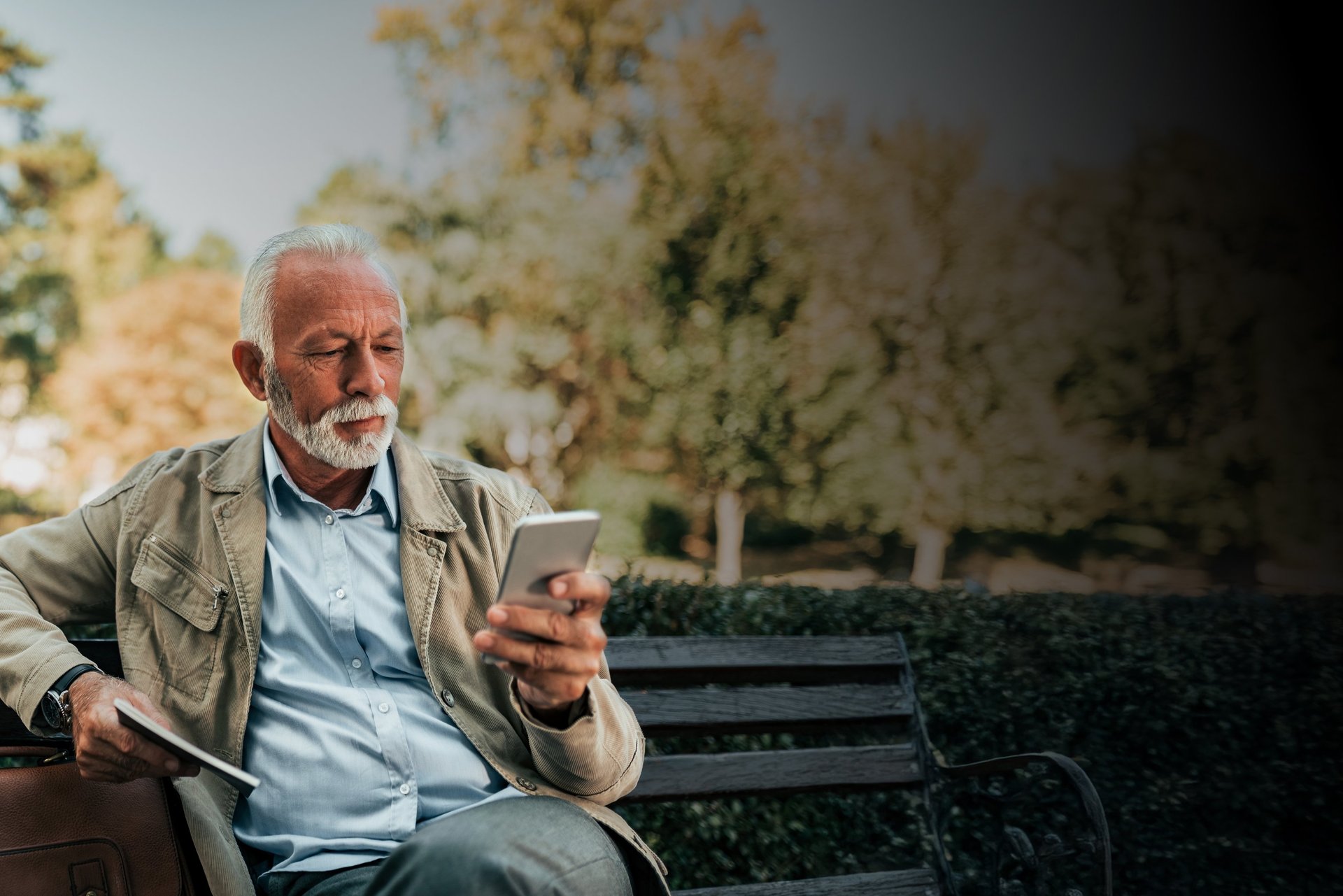 man sitting on gray arm chair using silver laptop computer on building balcony at daytime