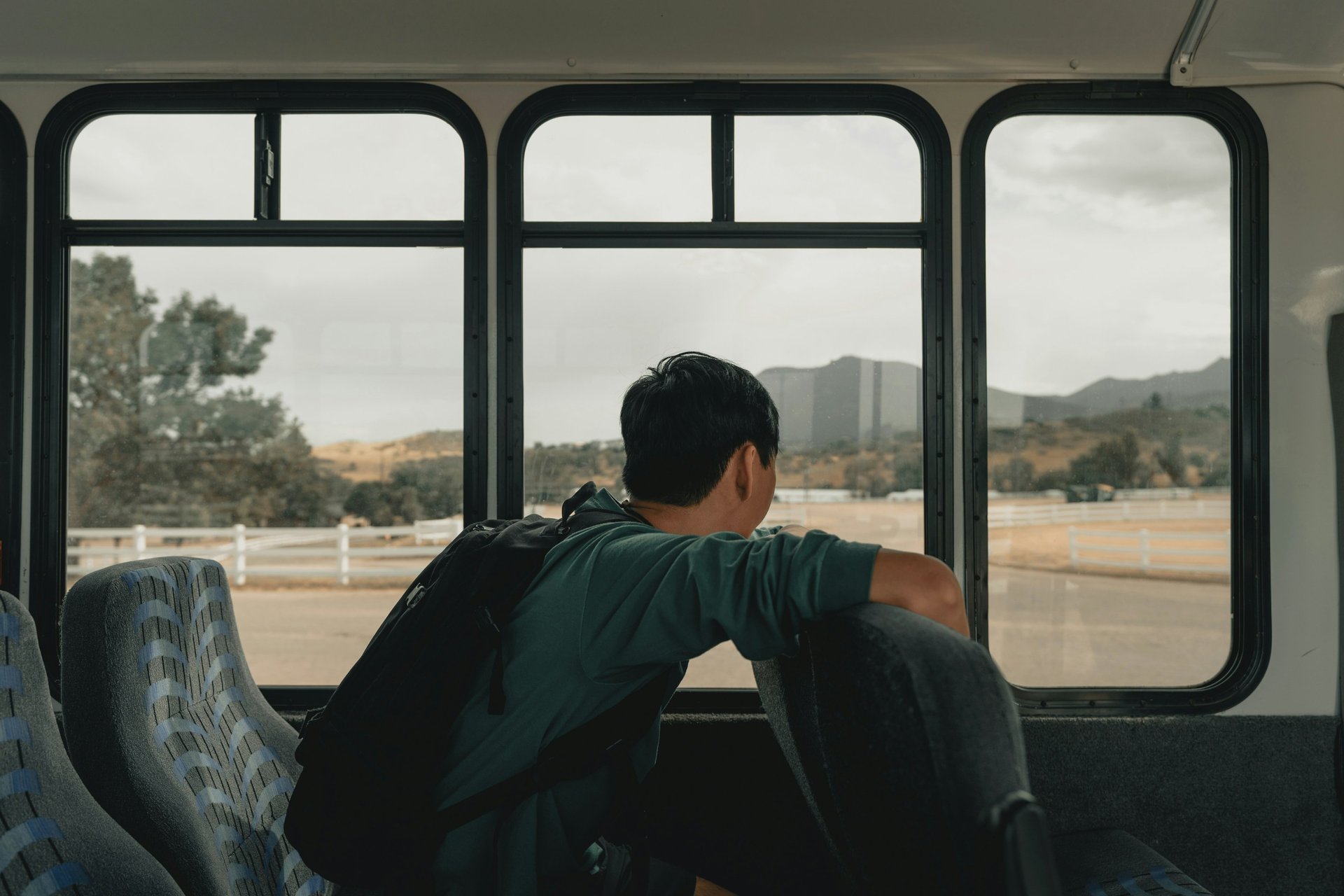 A man travelling on a train looking from the train window