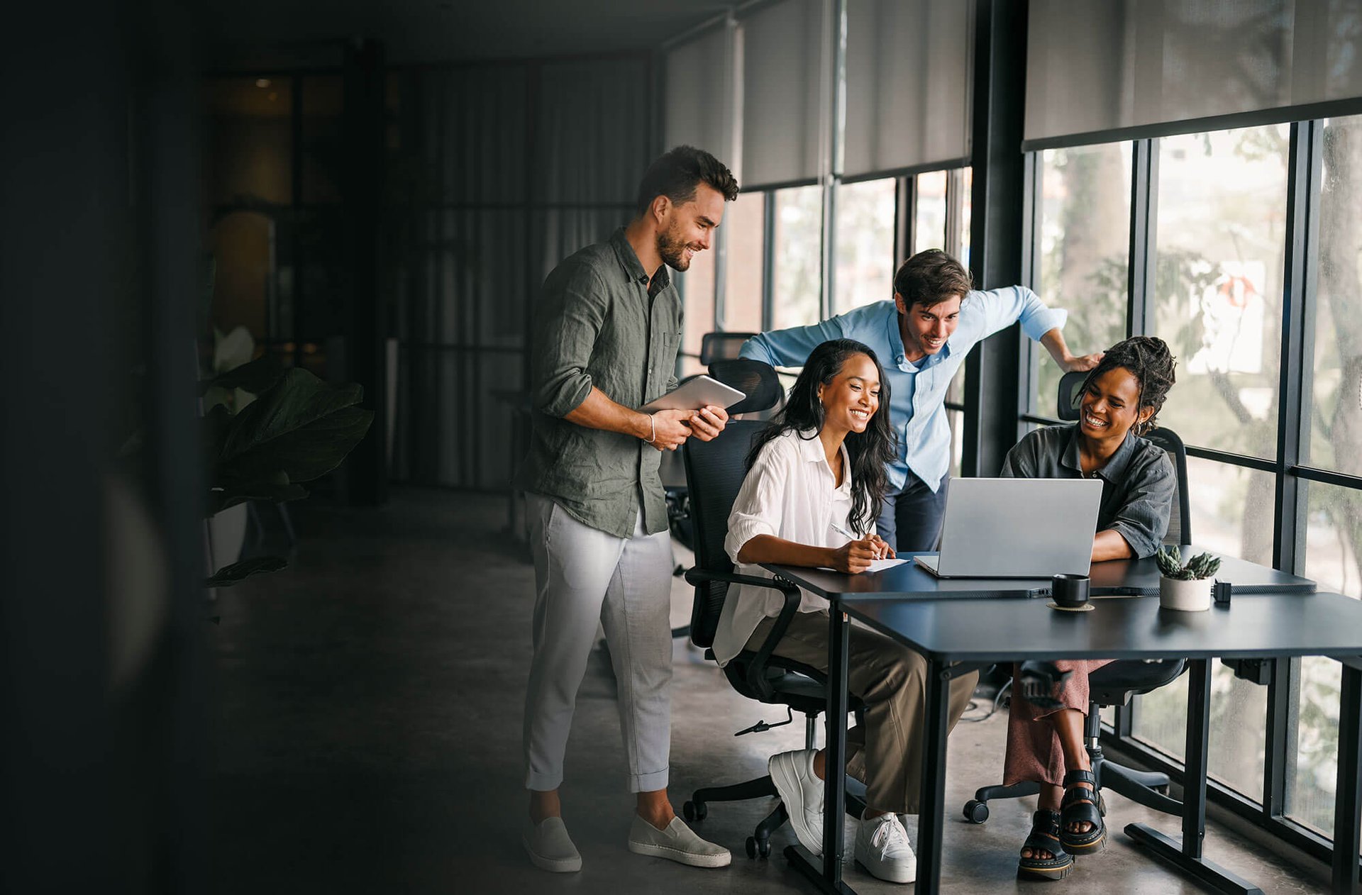 Group of coworkers with successful smiles looking over a computer