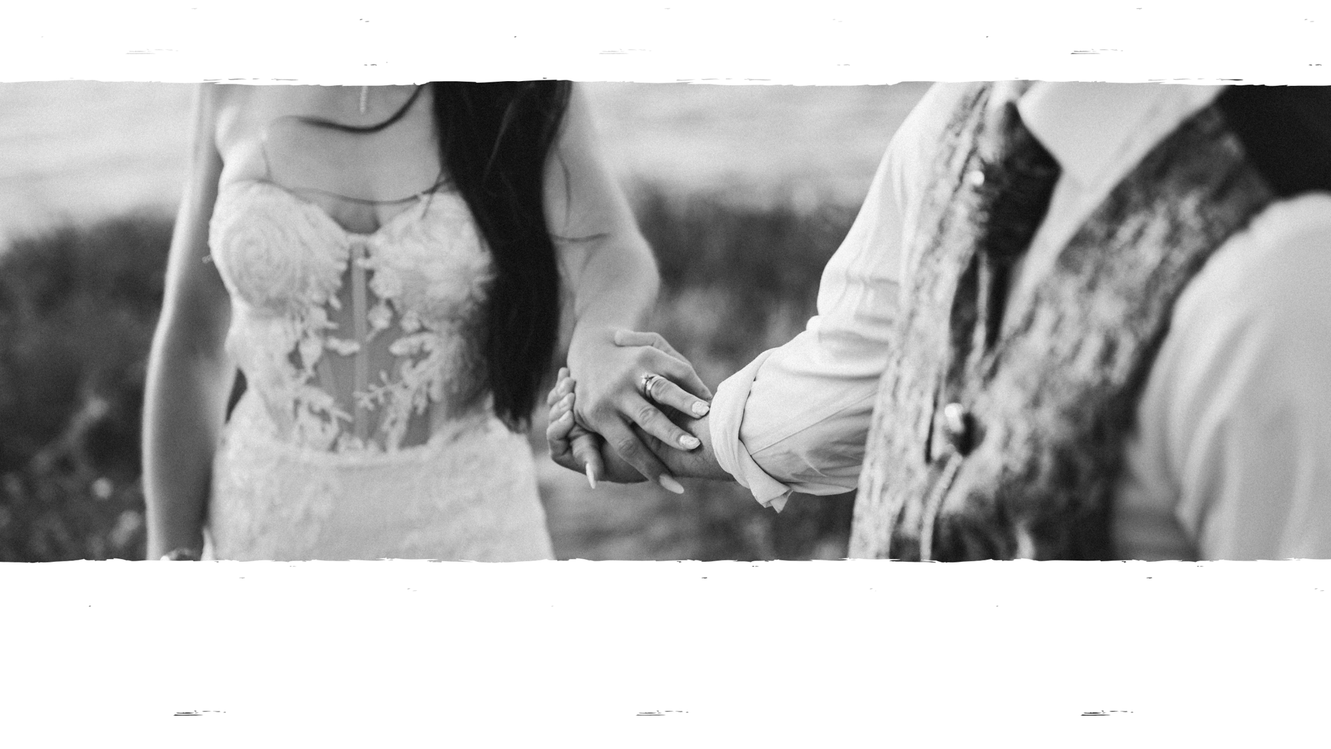 a newly married couple walking through a field