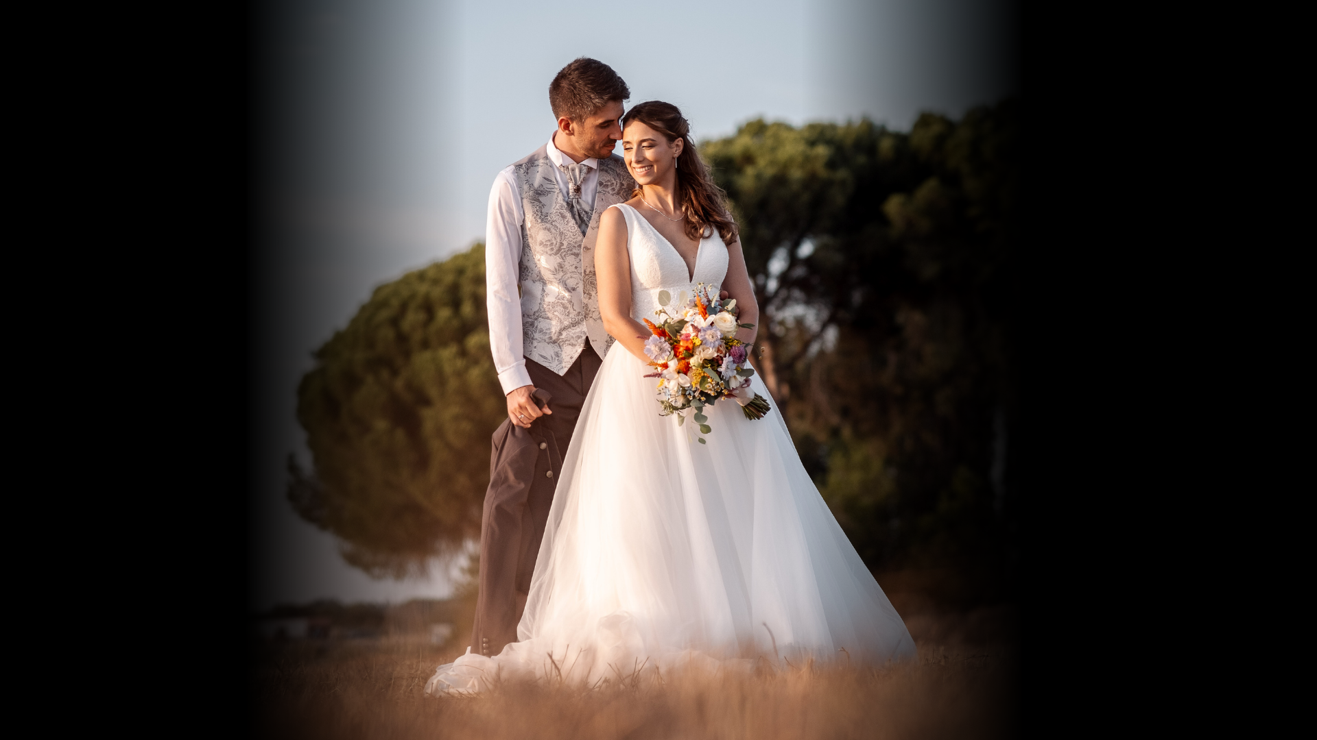 a newly married couple walking through a field