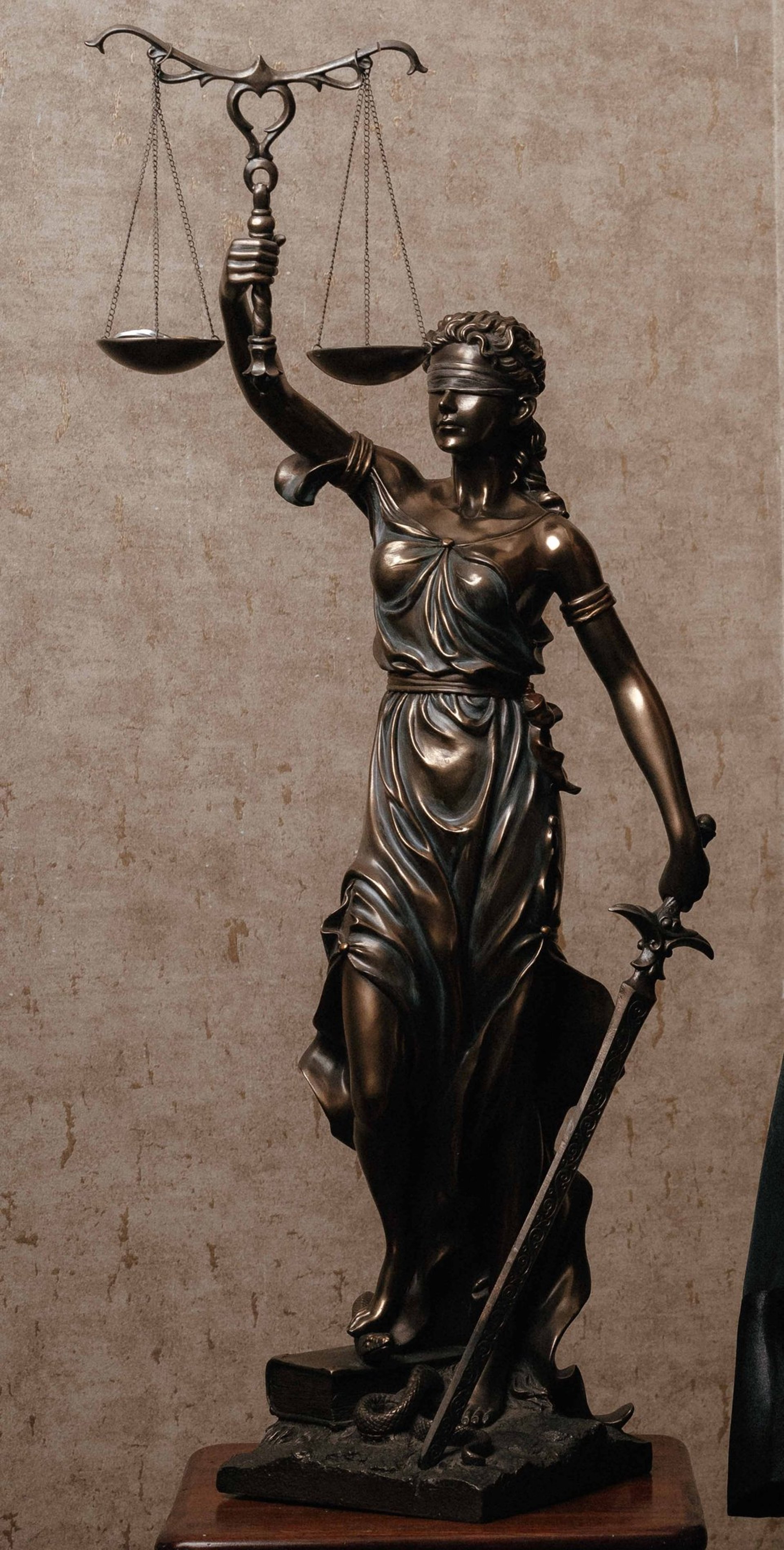 woman in dress holding sword figurine