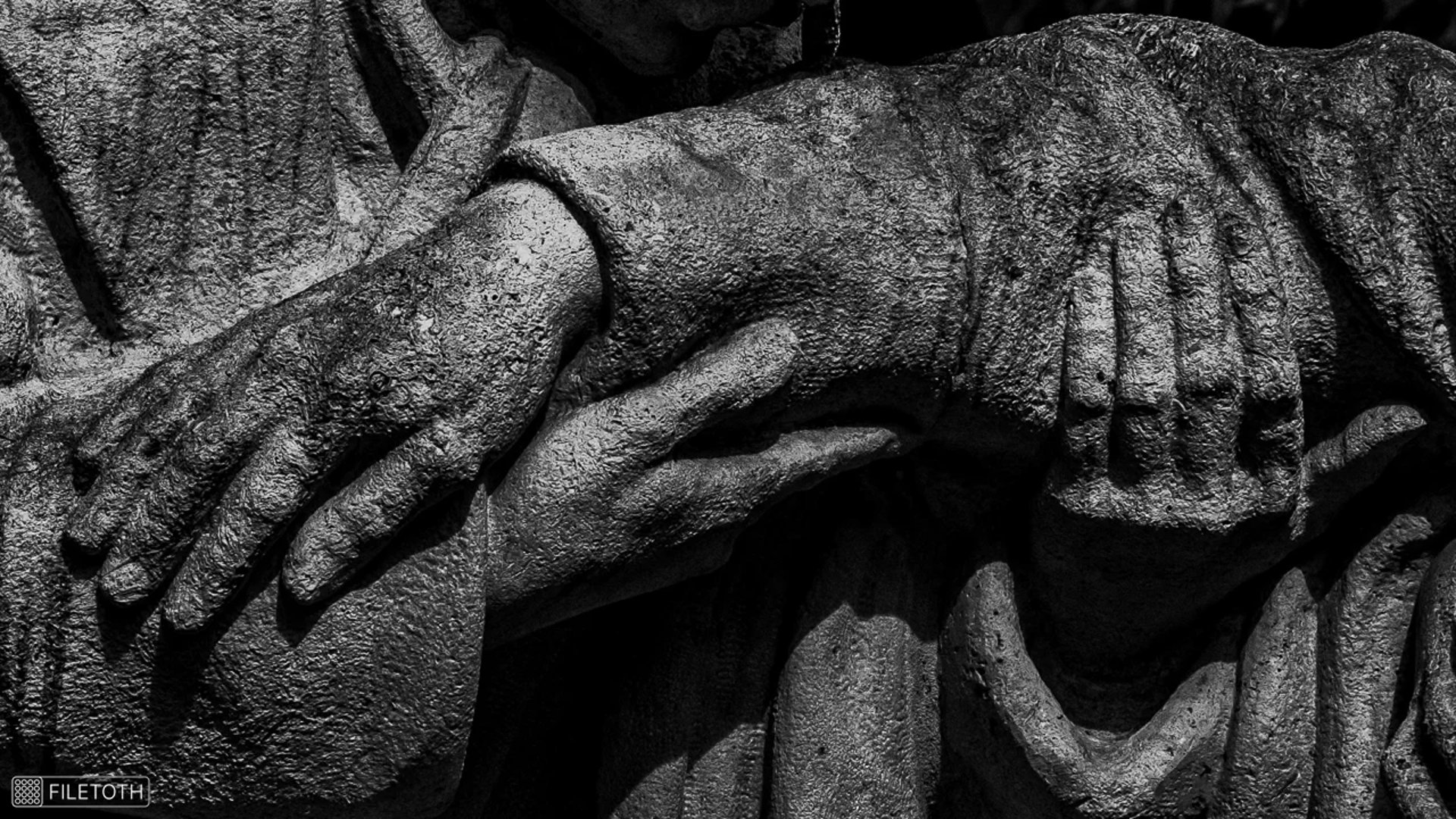 Close‑up on multiple hands of the heoric doctors' memorial.