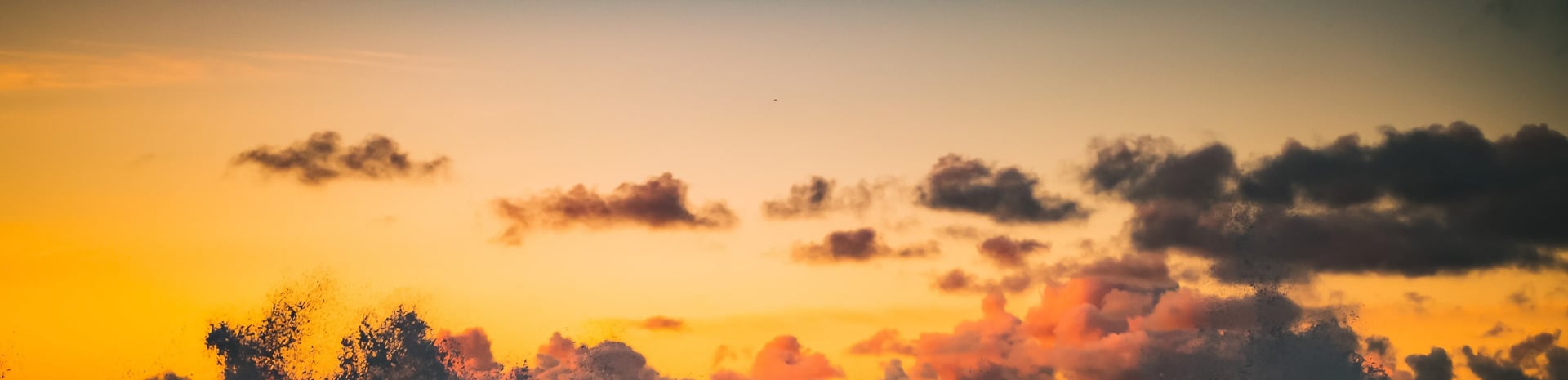 body of water near mountain under cloudy sky during daytime