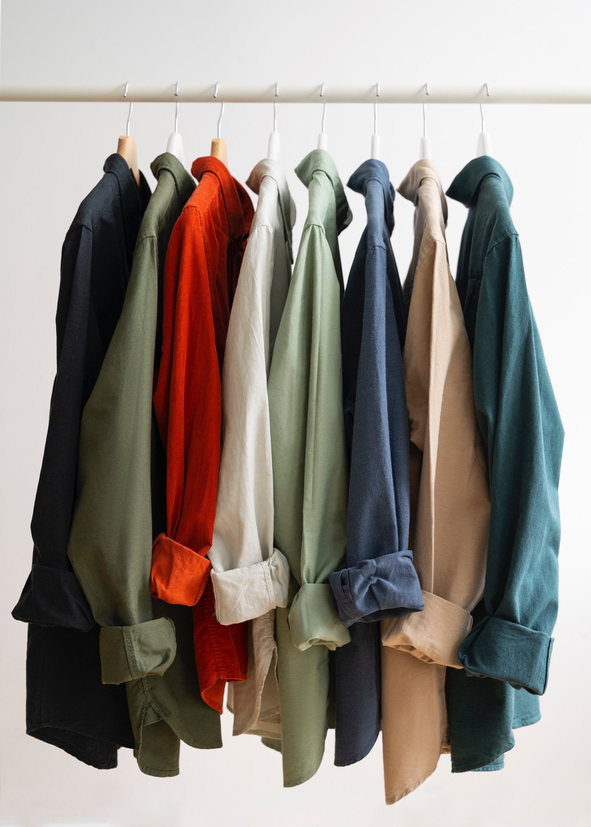 Shirts with colorful patterns hanging on a rack.