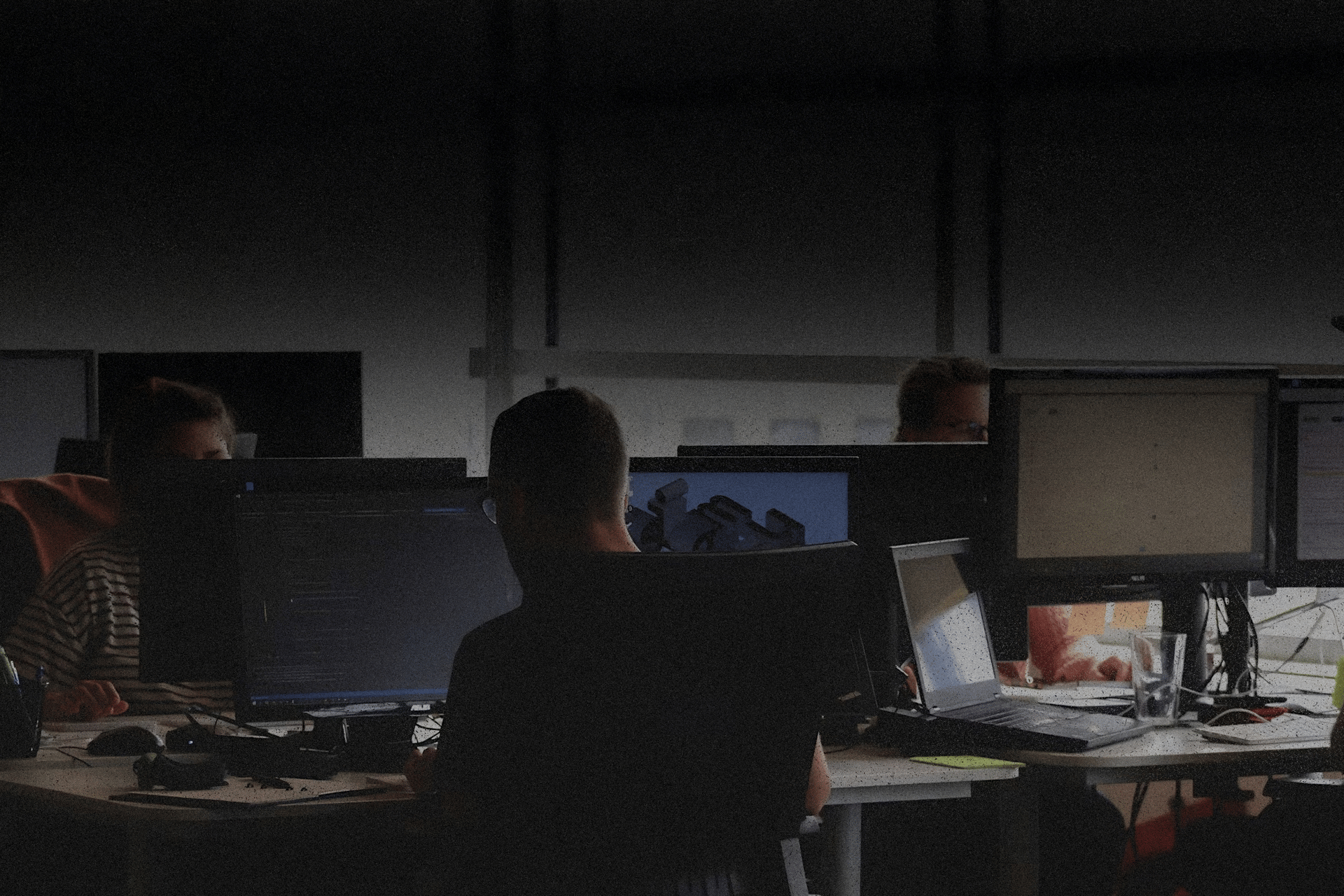a man sitting at a computer with headphones on