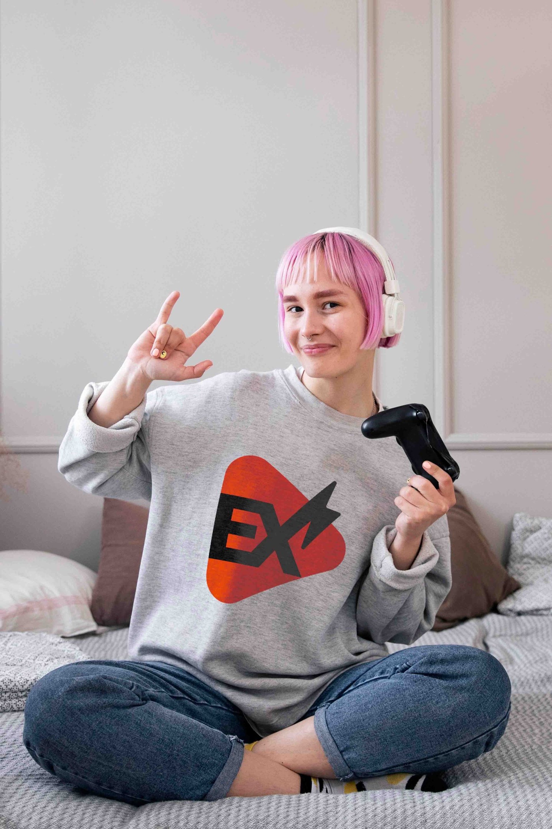 Mulher com cabelo rosa segurando um controle de videogame, expressando concentração e diversão em um ambiente de jogo.