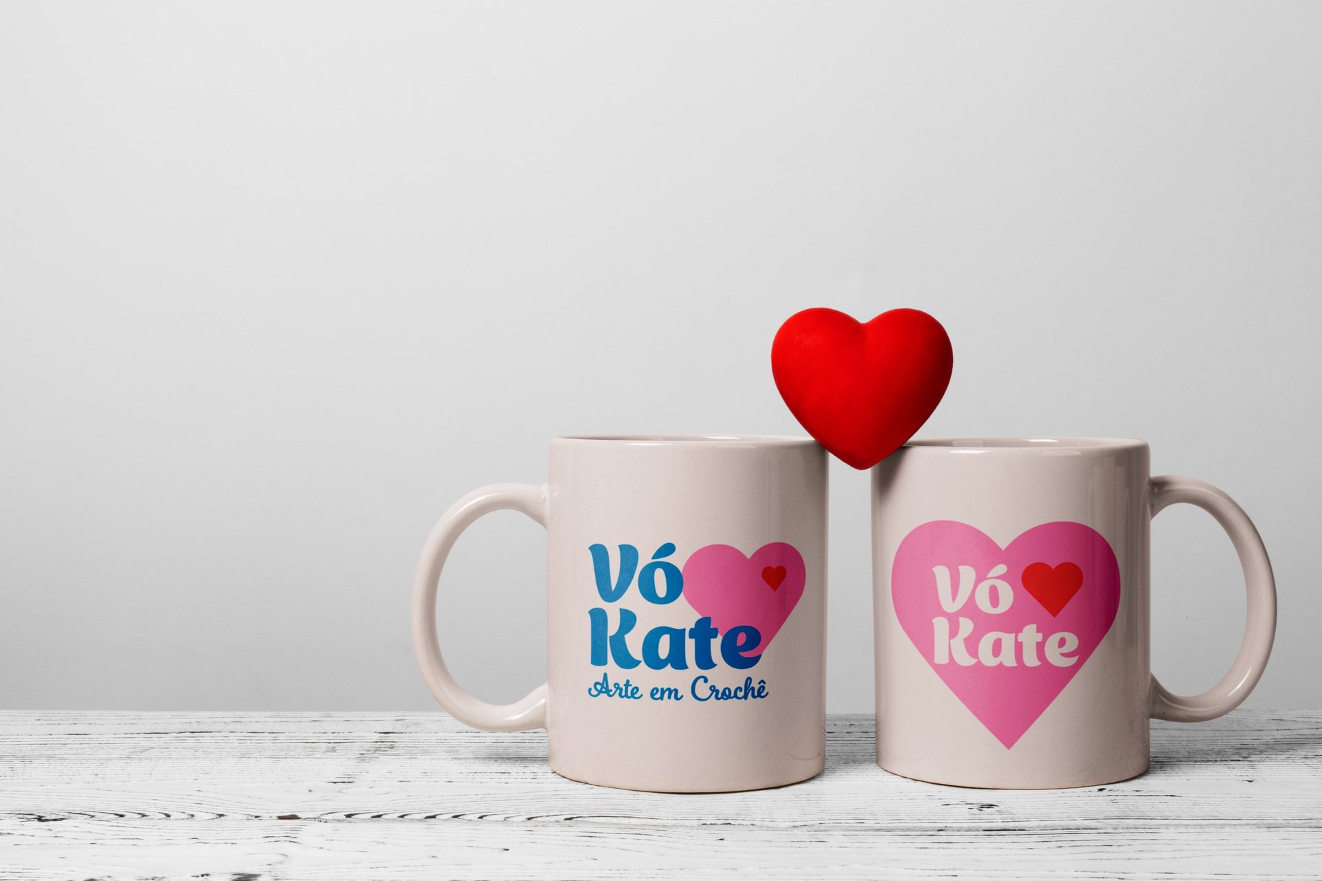 Duas canecas, com a palavra "vó kate", dispostas lado a lado em um fundo neutro.