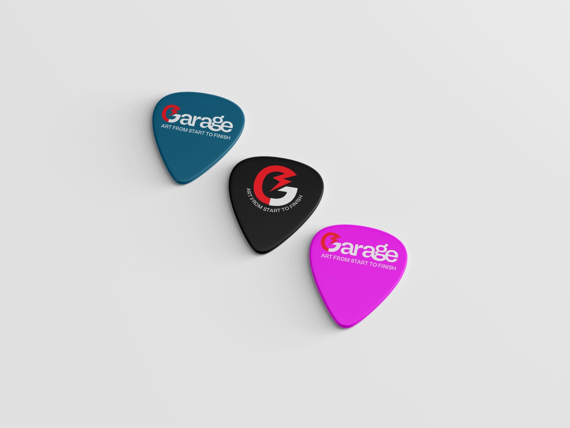 Três paletas coloridas com a estampa da logo da linha de cabos para instrumento Garage.