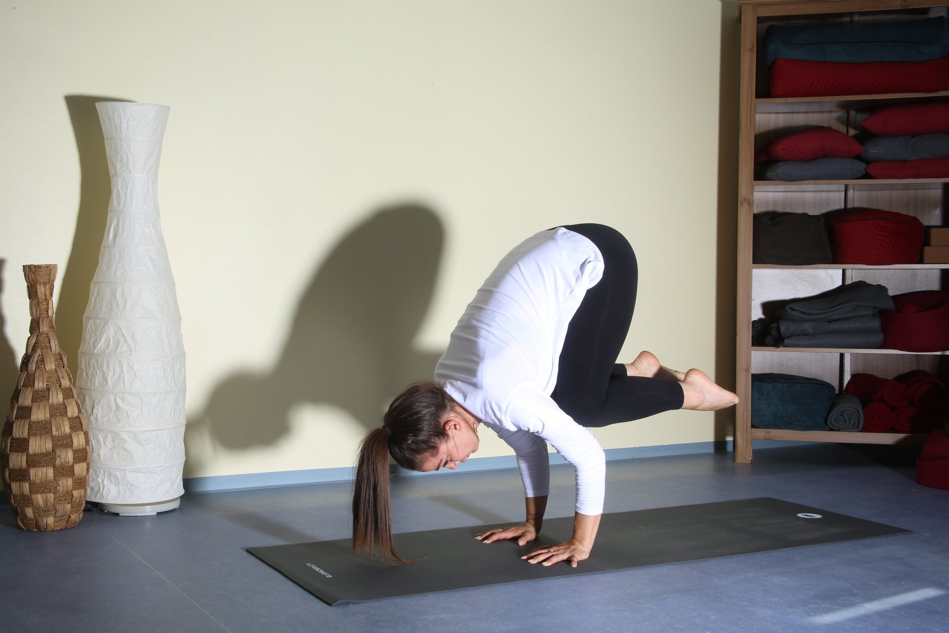 woman in white tank top bending her body on floor