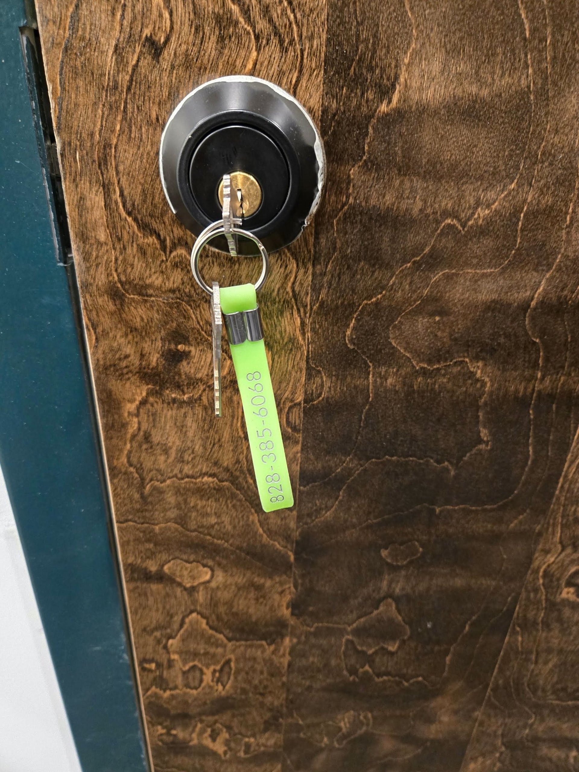 Key in a door lock with a green key tag