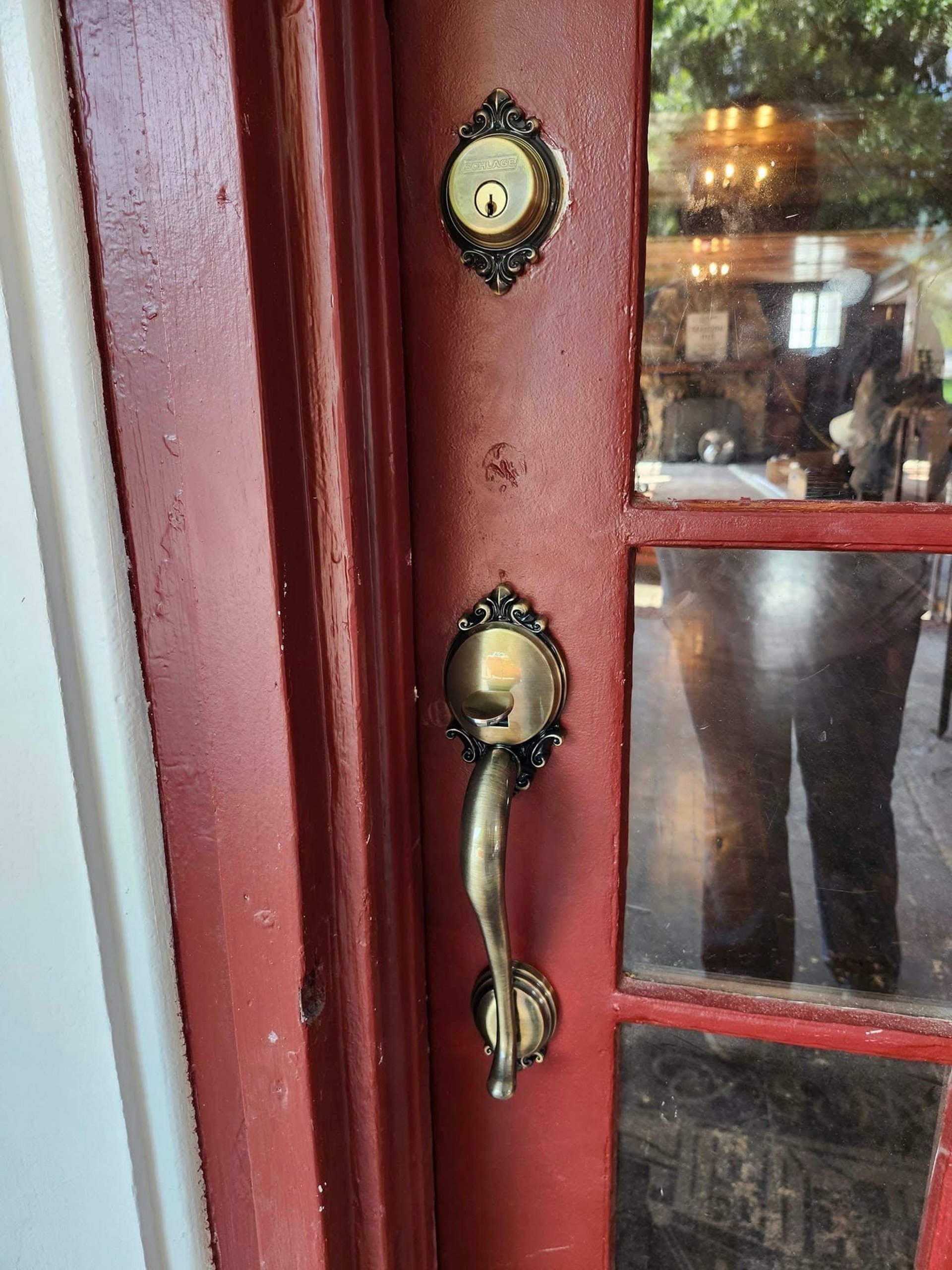 Red residential front door with brass deadbolt and handle lockset