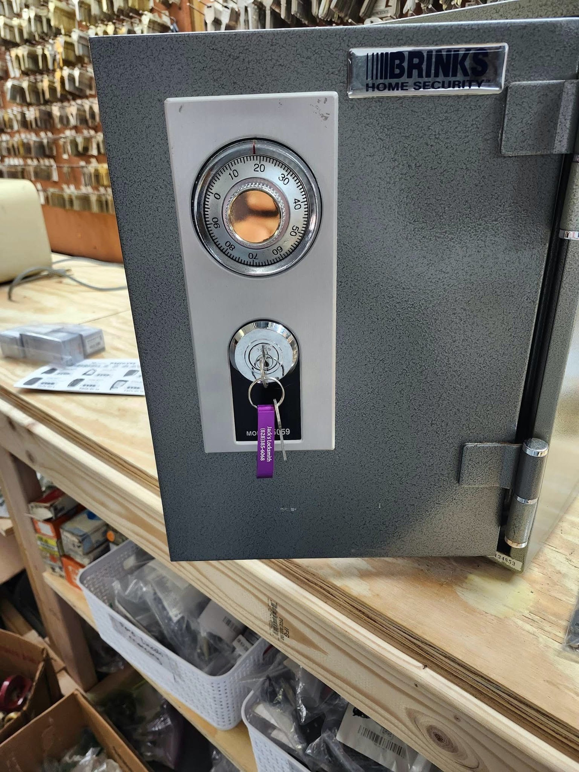 A grey safe with a combination dial and key lock visible on the front