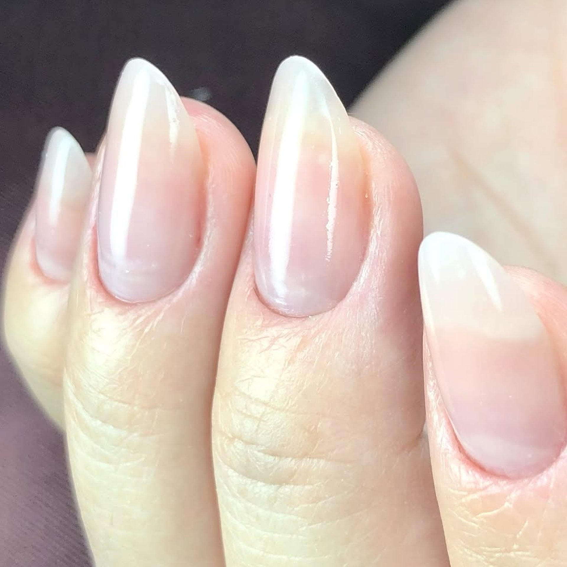 Alongamento formato stiletto ou amendoado tom leitoso natural.