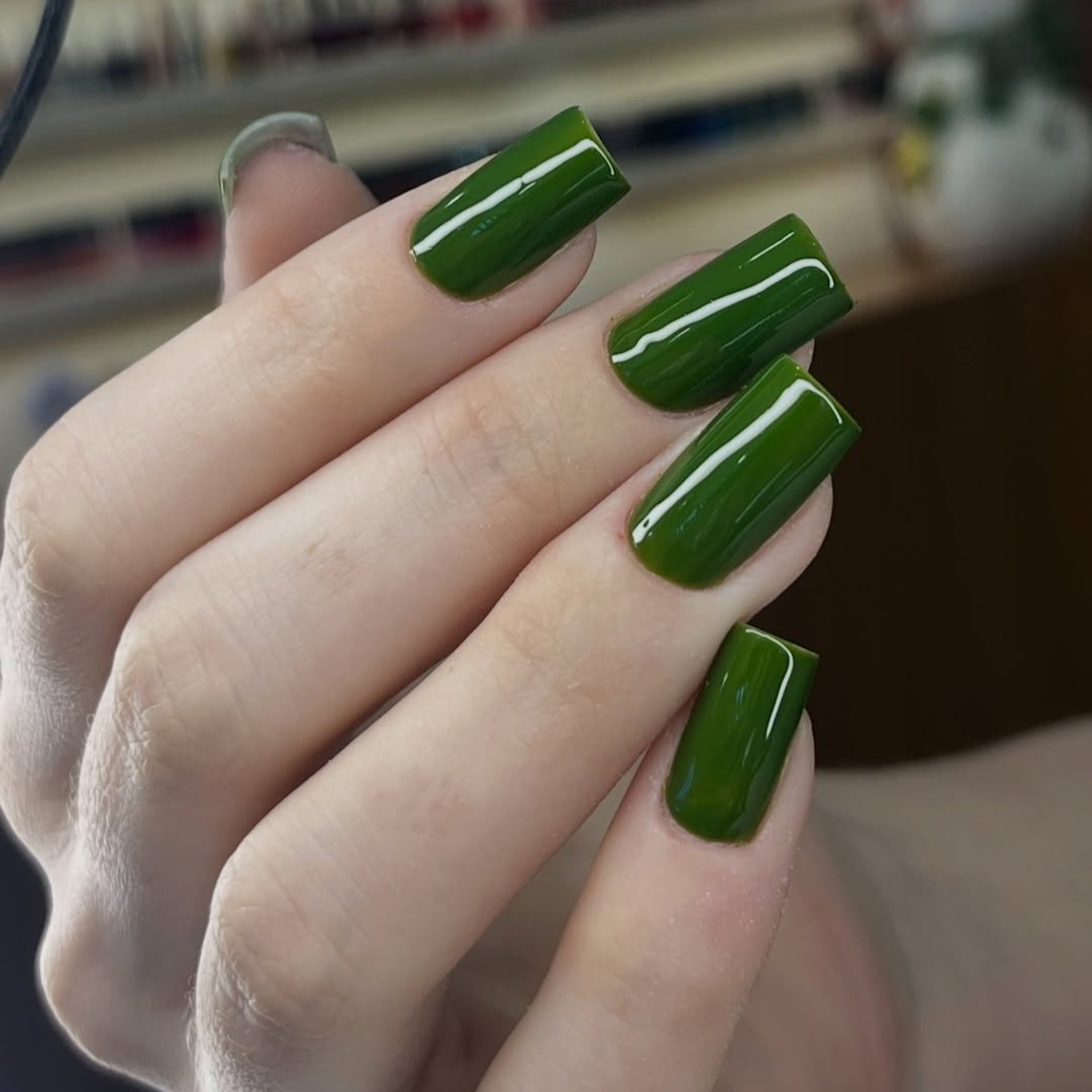 Unha de fibra quadrada cor verde musgo com nail art minimalista branca.