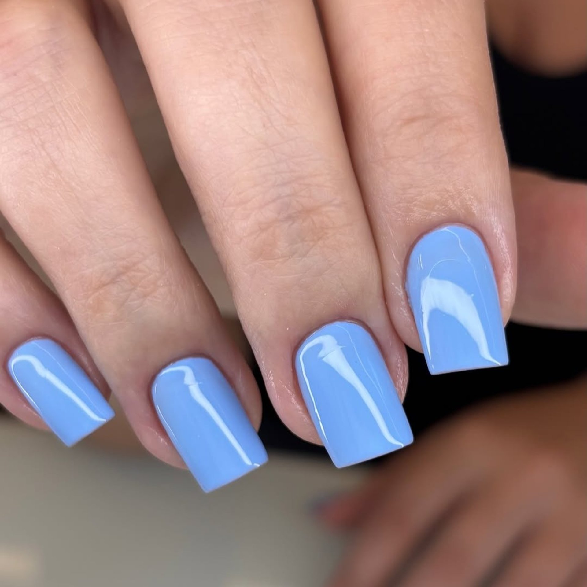 Alongamento de unhas quadradas esmaltação azul claro brilhante.
