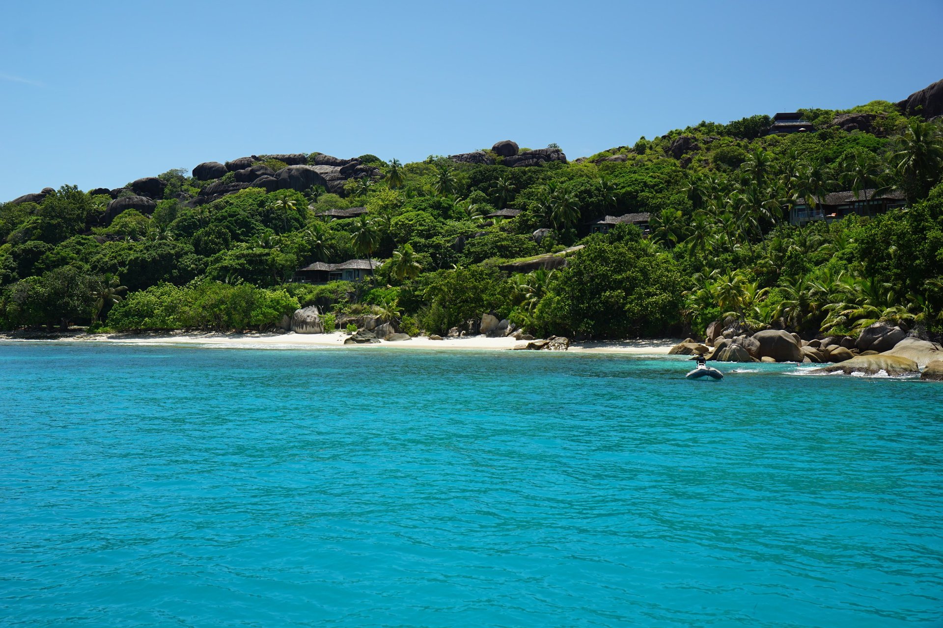 Aerial view of a coastal island and stunning blue waters.