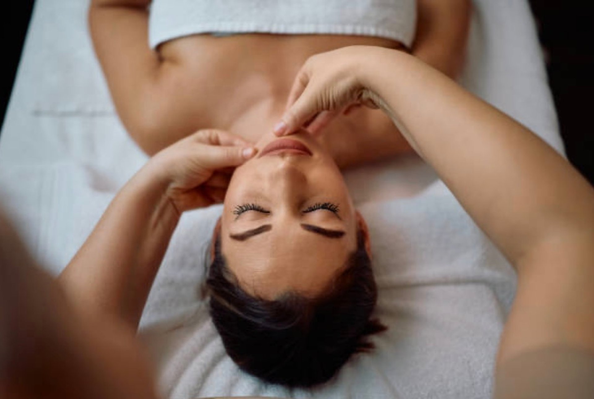 a woman getting a facial massage on her face